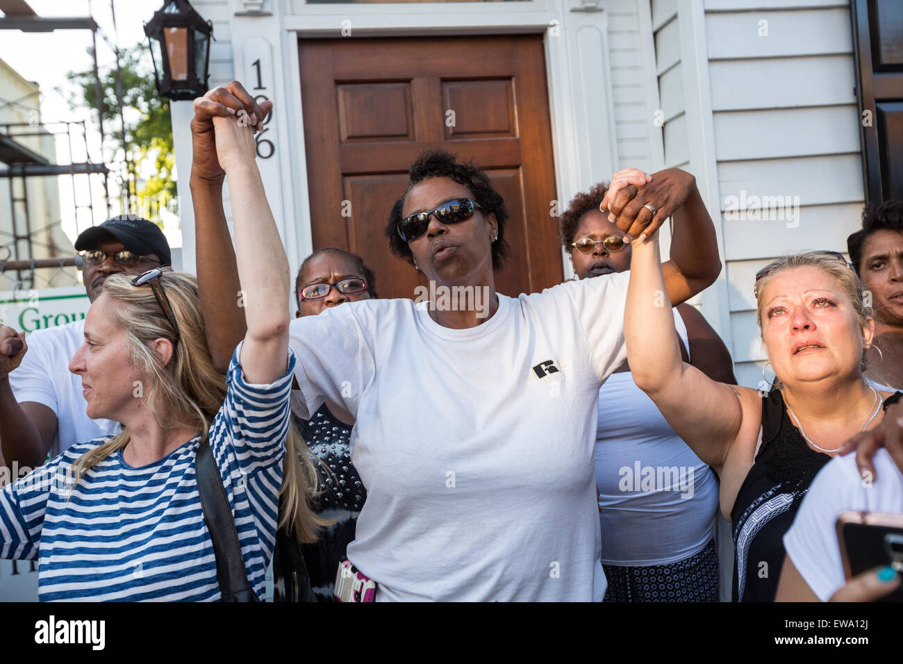 Trauernden halten Hände in der Einheit während einer spontanen Gebet an einem improvisierten Denkmal außerhalb der historischen Mutter Emanuel African Methodist Episcopal Church 20. Juni 2015 in Charleston, South Carolina. Früher in der Woche getötet ein weißes Supremacist Schütze 9 Mitglieder in der historisch schwarze Kirche. Stockfoto