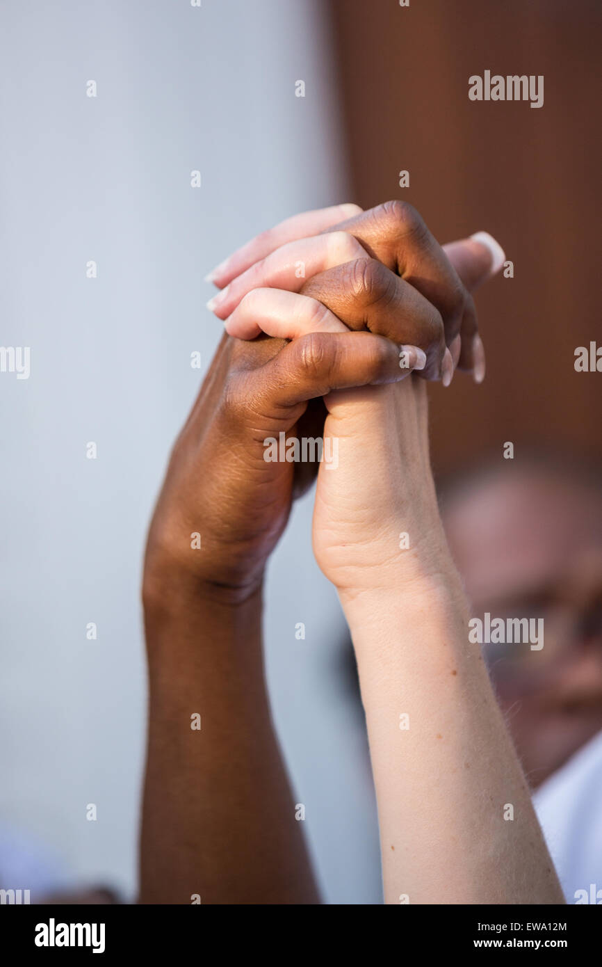 Trauernden halten Hände in der Einheit während einer spontanen Gebet an einem improvisierten Denkmal außerhalb der historischen Mutter Emanuel African Methodist Episcopal Church 20. Juni 2015 in Charleston, South Carolina. Früher in der Woche getötet ein weißes Supremacist Schütze 9 Mitglieder in der historisch schwarze Kirche. Stockfoto