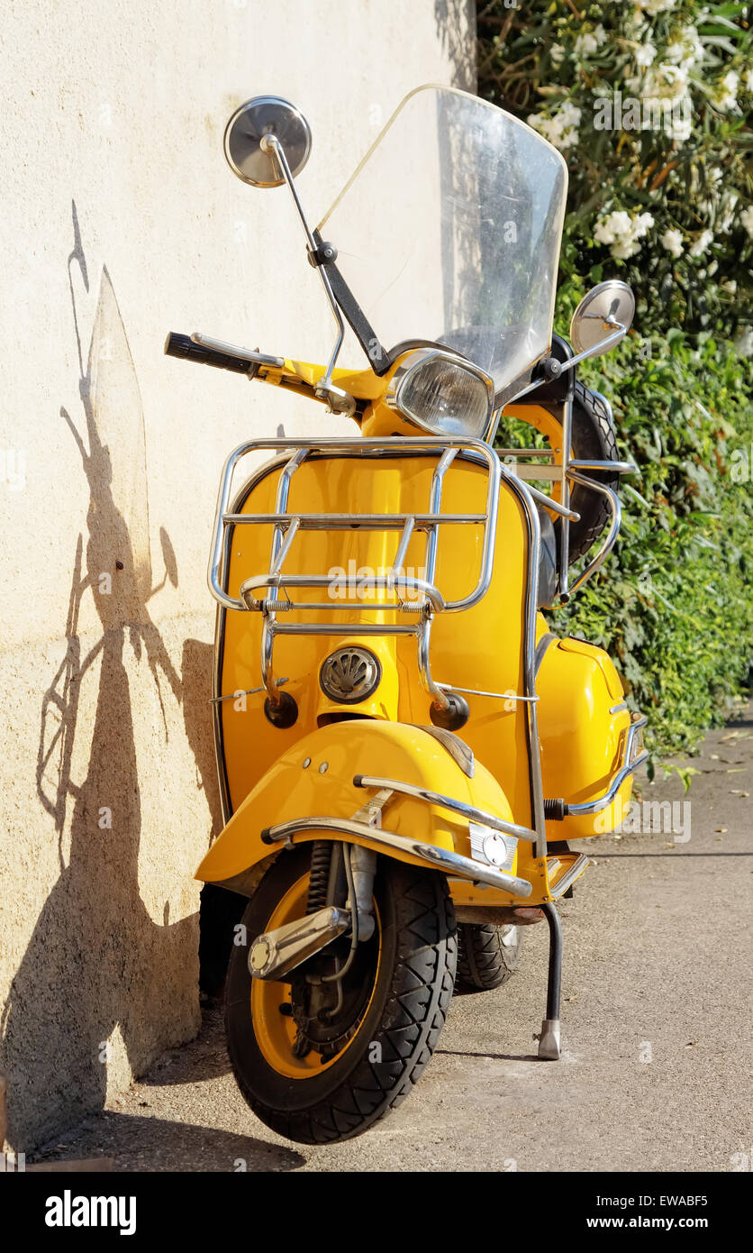 gelbe Retro-Motorrad stehen gegen die Wand Stockfoto