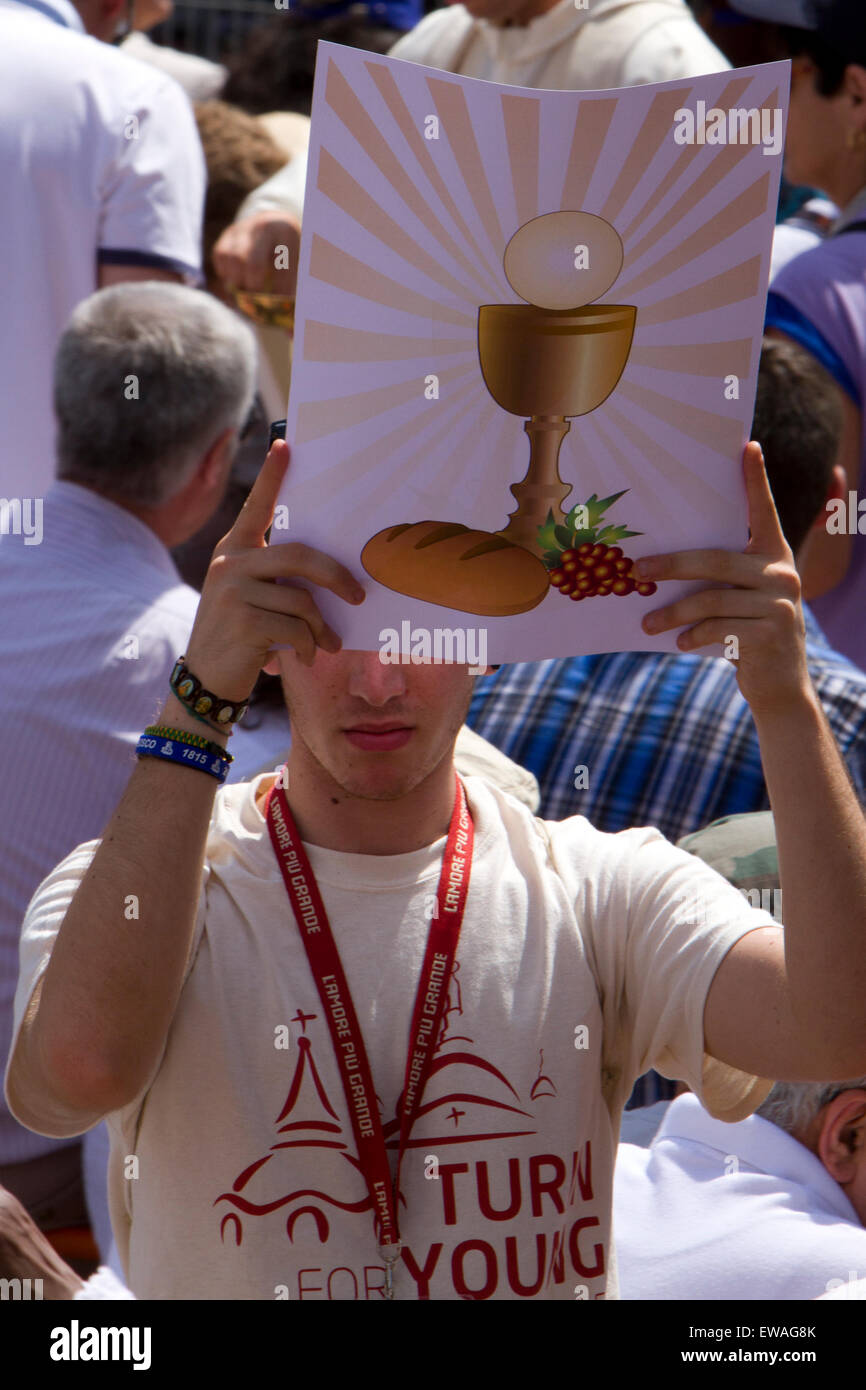 Ein junger Mann halten ein Plakat mit Symbolen der christlichen Eucharistie Sakrament während einer Messe. Stockfoto