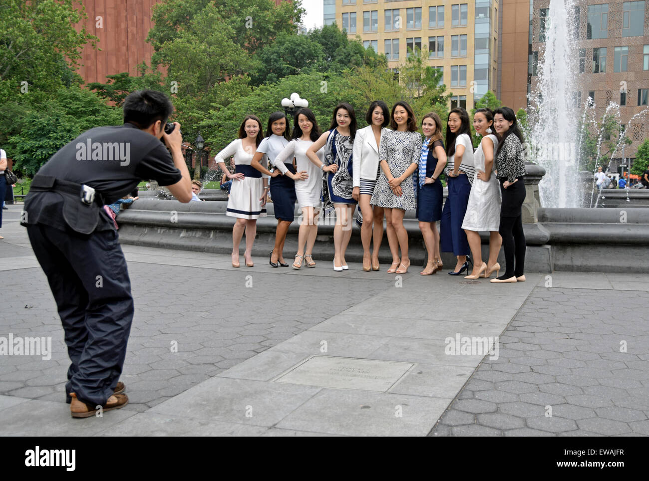 Ein Fotograf macht Fotos von attraktiven Frauen, die zusammen für einen Junggesellenabschied im Washington Square Park in New York City. Stockfoto