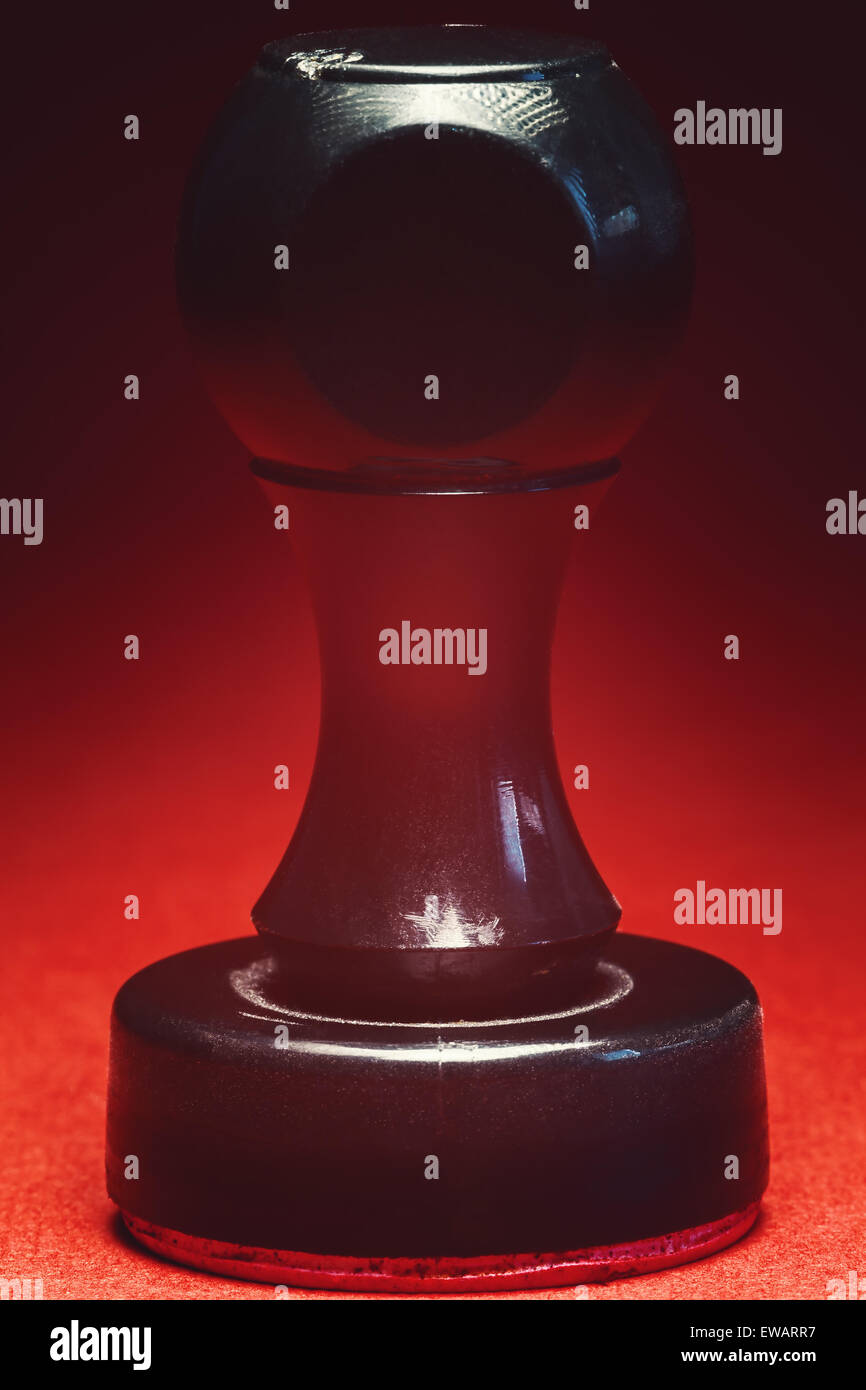 Alten schwarzen Kunststoff Stempel auf rotem Grund, Nahaufnahme. Stockfoto