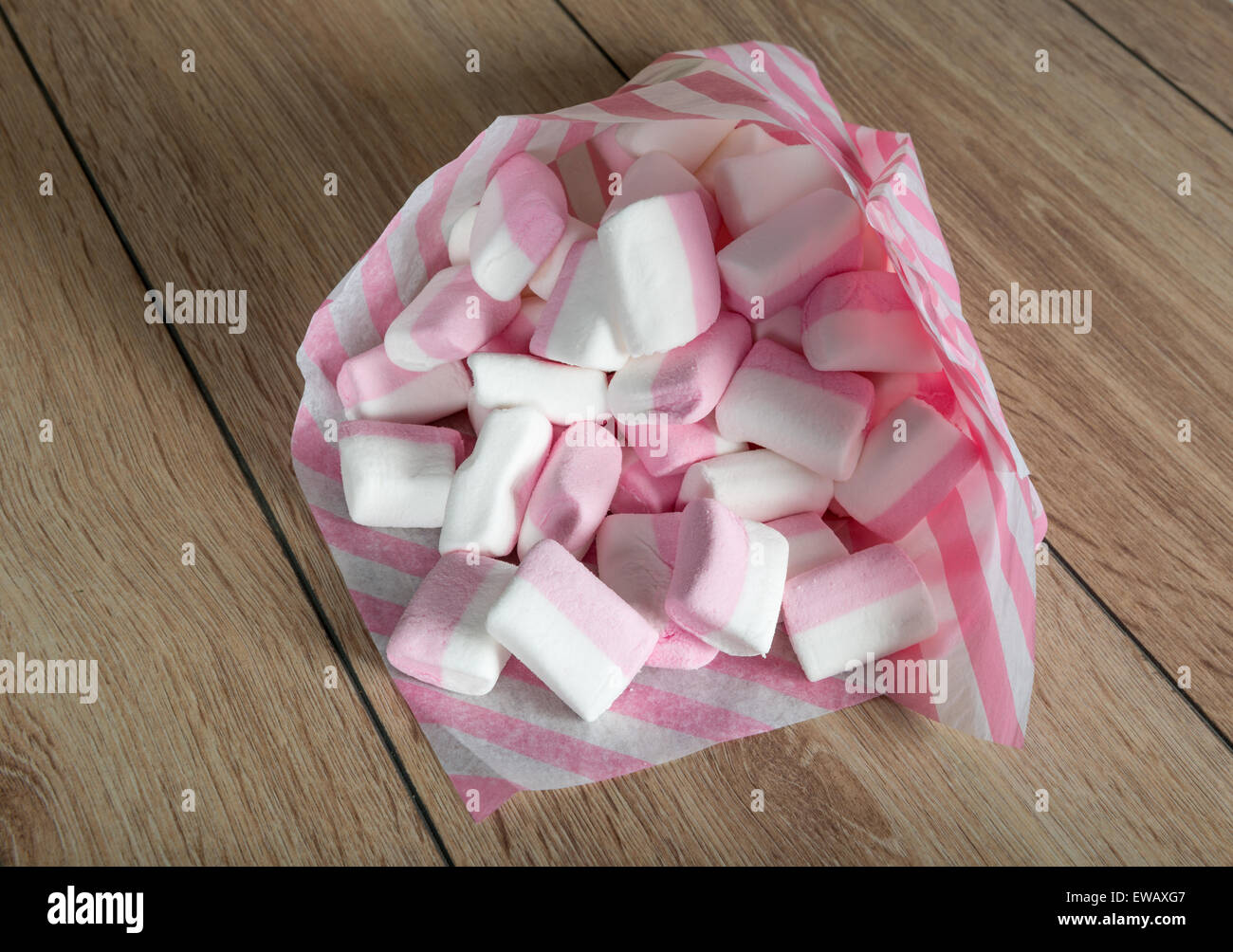 Marshmallows weiß und rosa in Papiertüten auf eine Holzoberfläche Stockfoto