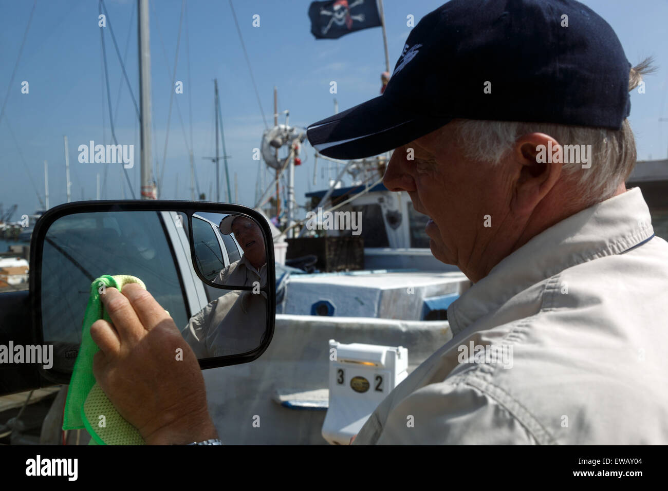 Ältere männliche Reinigung Außenspiegel des Fahrzeugs Stockfoto