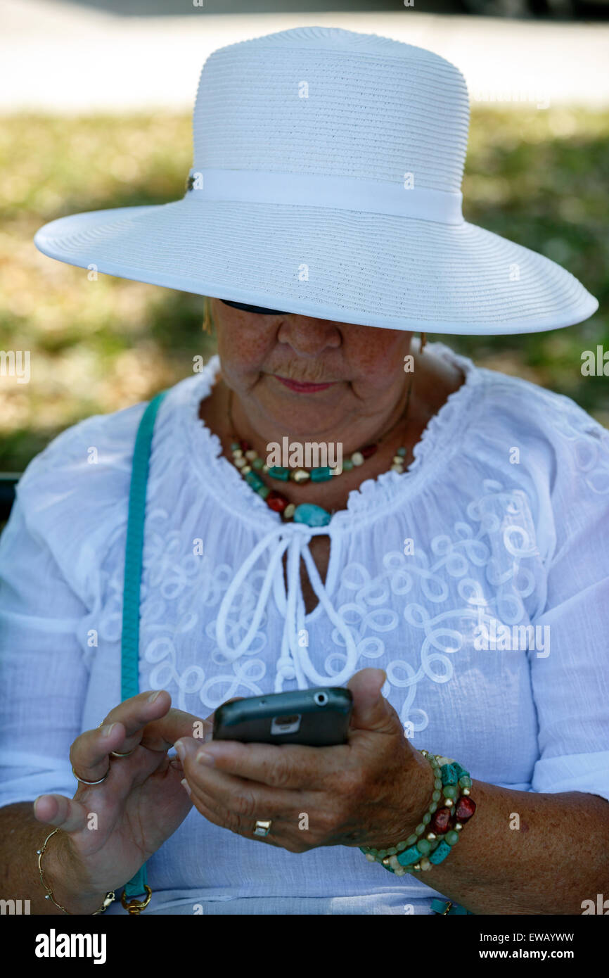 Senior weiblichen SMS auf ihr Handy silver surfer Stockfoto