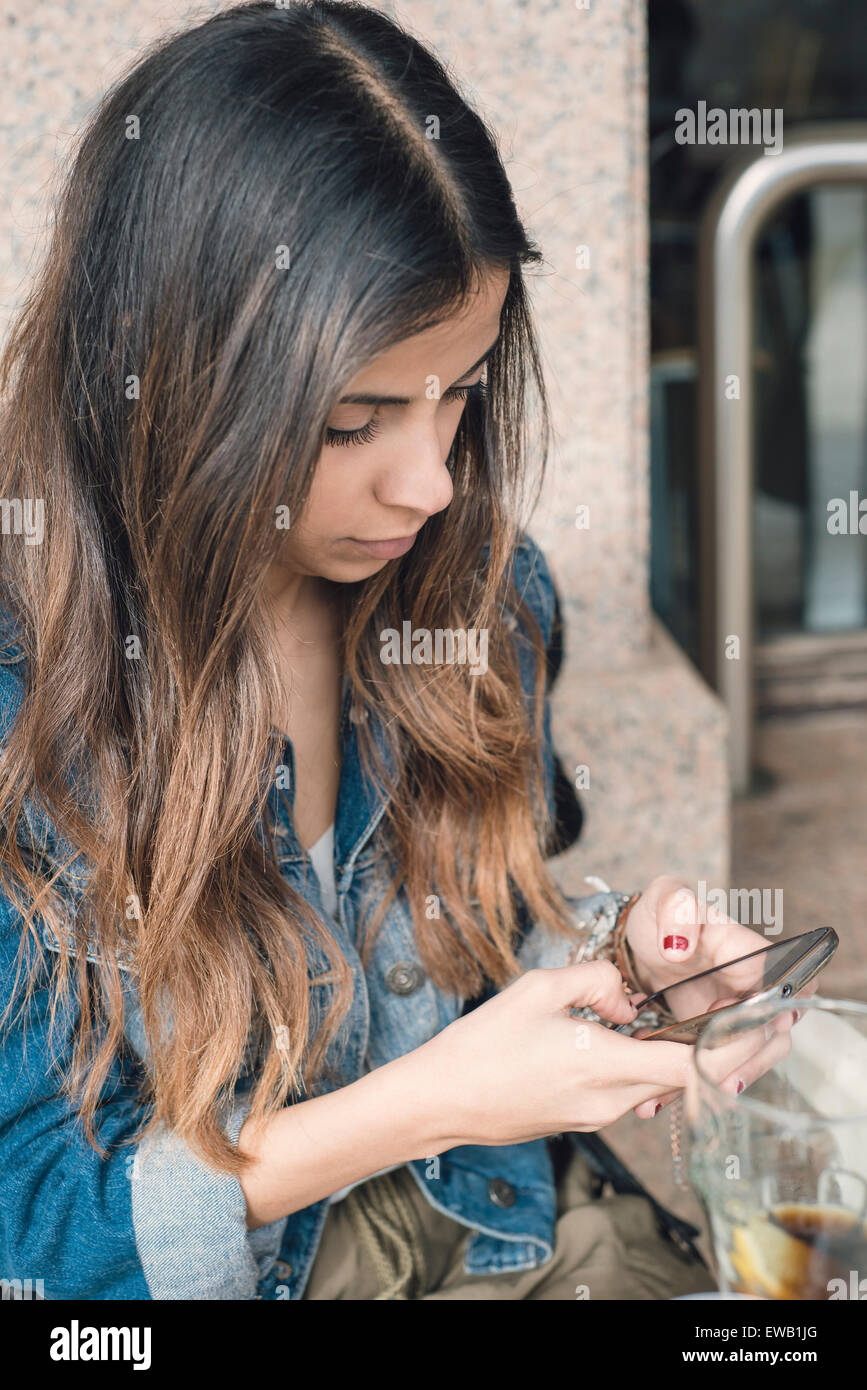 Brünette Frau eine SMS mit ihrem Smartphone Stockfoto