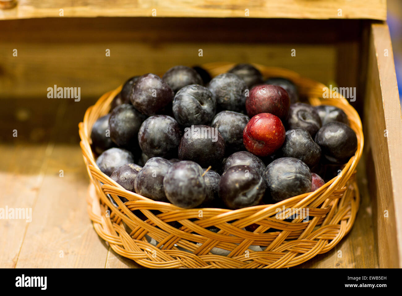 reife Pflaumen in Korb am Bauernhof oder Lebensmittelmarkt Stockfoto