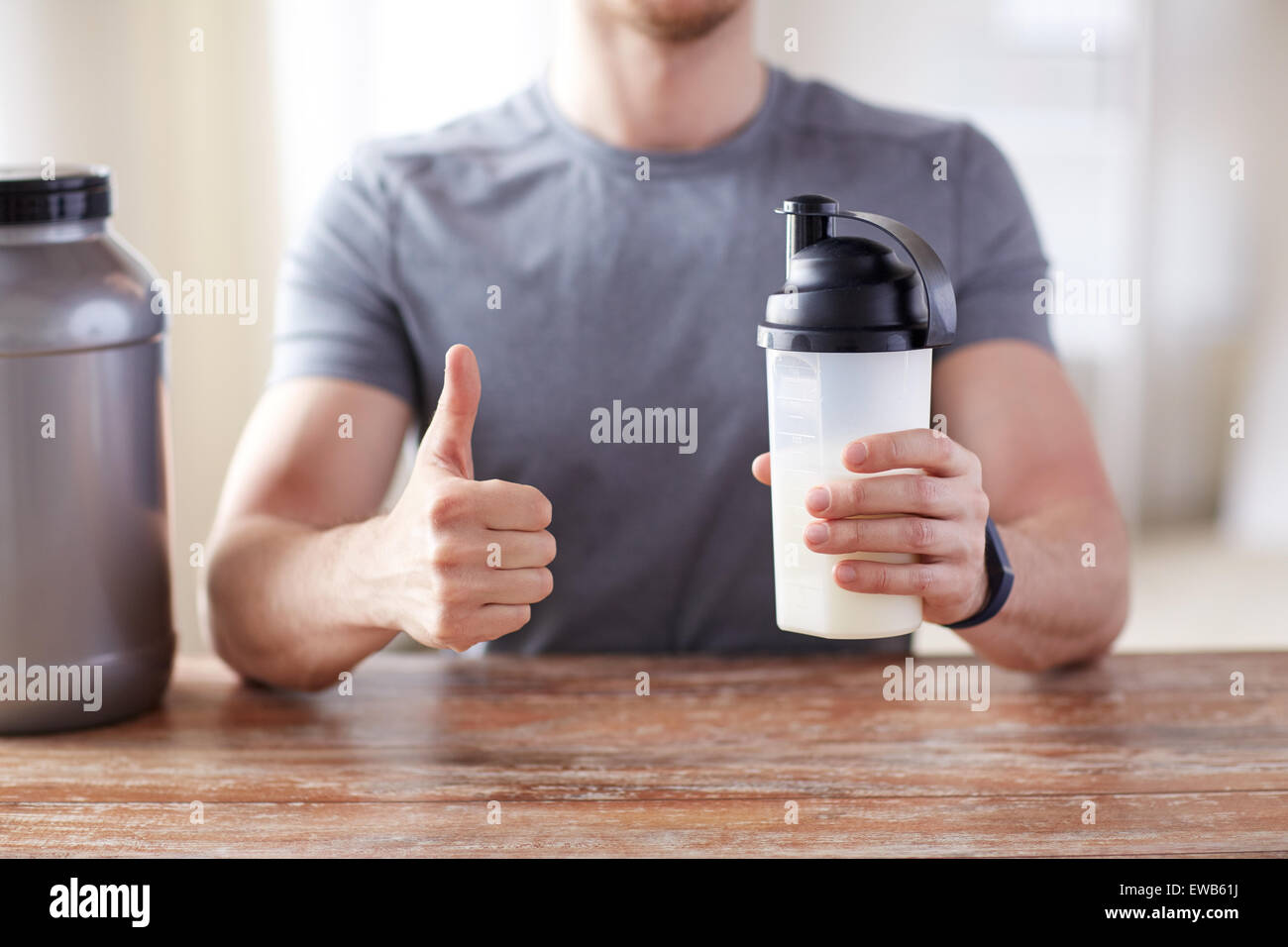 Mann mit Protein shake Flasche Daumen auftauchen Stockfoto