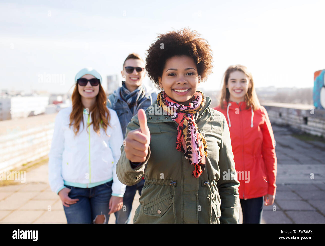 glücklich Teenager Freunde auftauchend Daumen auf Straße Stockfoto