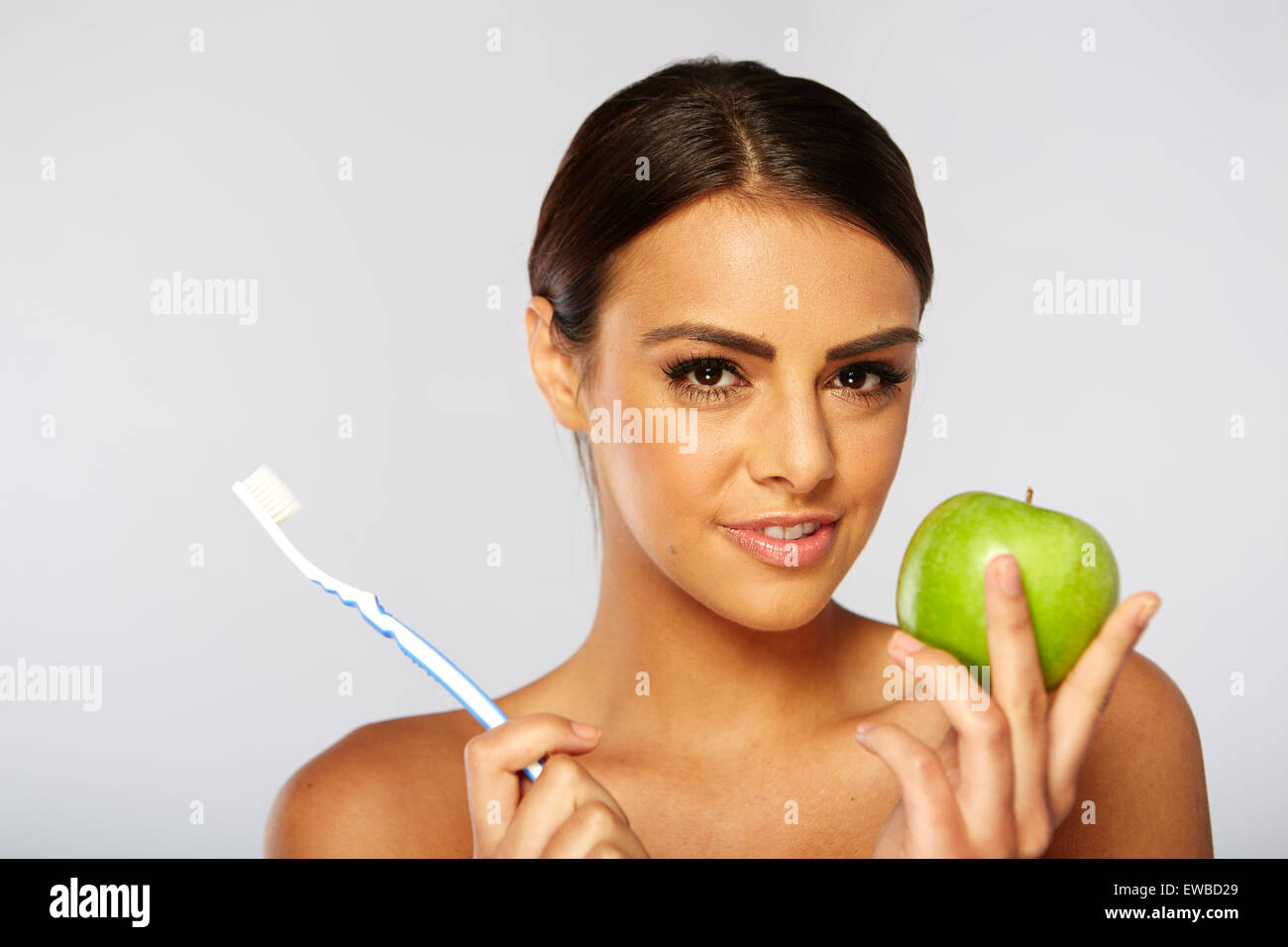 Porträt der Frau hält einen Apfel und Zahnbürste. Stockfoto
