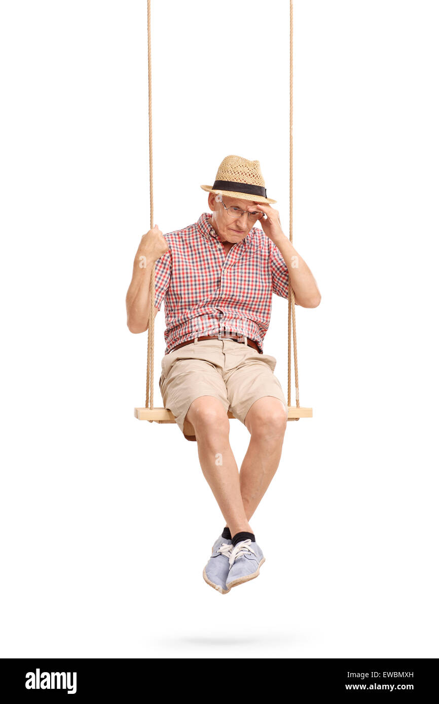 Vertikale Schuss von einem depressiven senior Mann sitzt auf einer Schaukel und die Erinnerung an etwas isoliert auf weißem Hintergrund Stockfoto