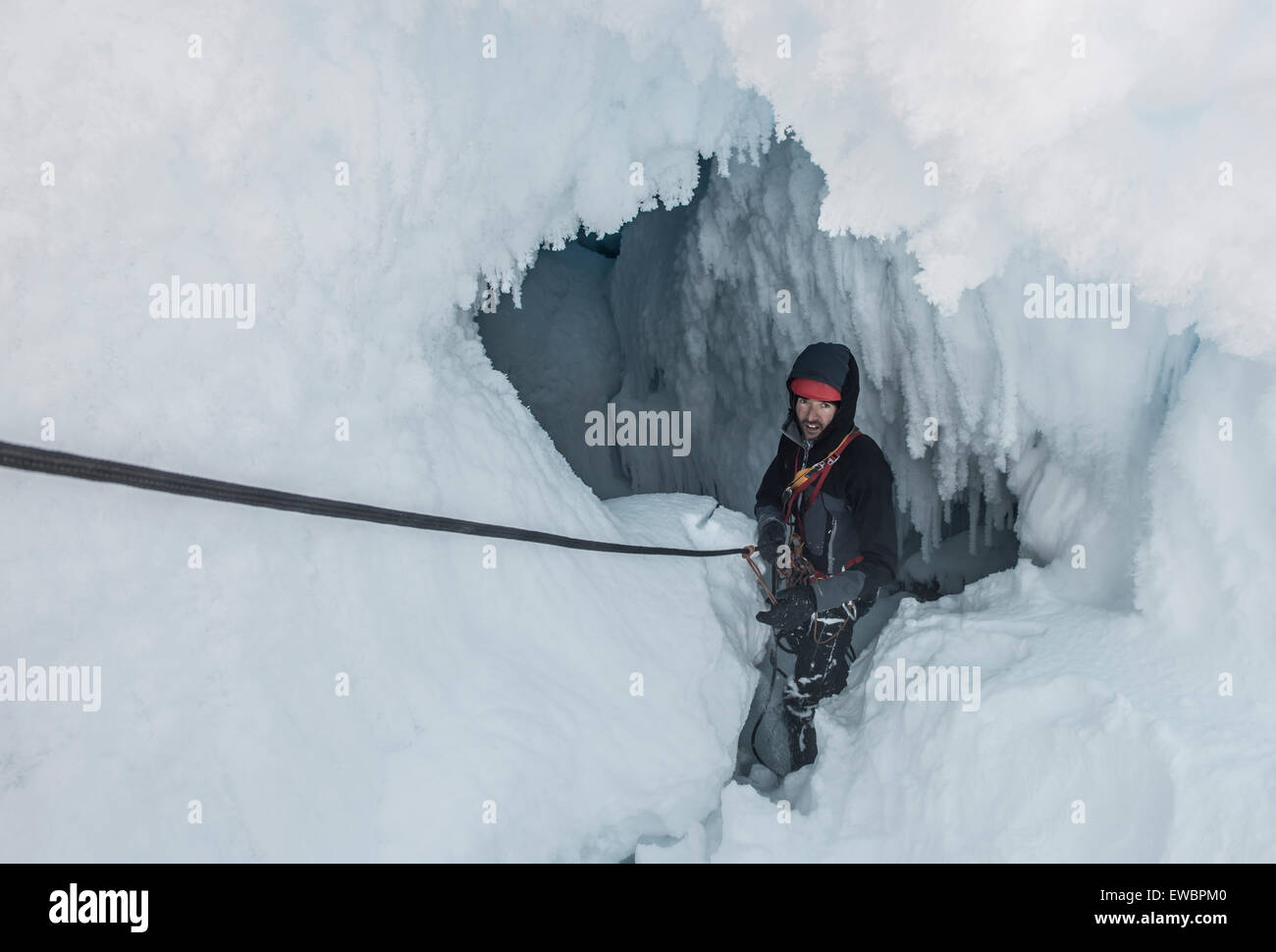 Mann Abseilen in der Dampfgrotte am Mount Erebus, Antarktis. Stockfoto