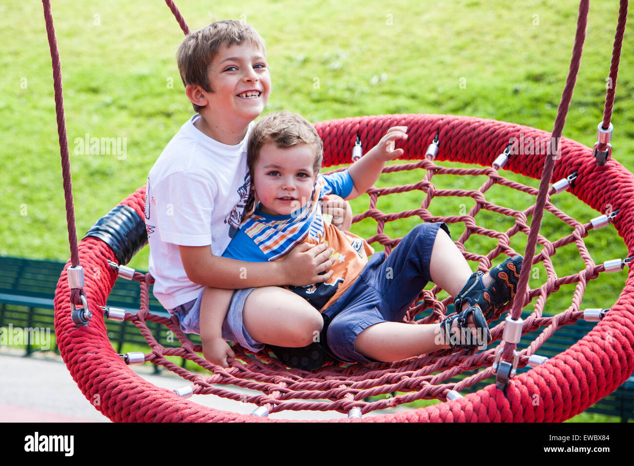 zwei Kinder auf dem Spielplatz Spaß am swing-Runde Stockfoto
