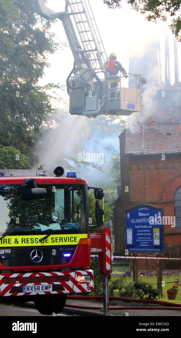 Fleet Hampshire, UK. 22. Juni 2015. Vierzig Feuer Figthers kämpfen um Kontrolle ein Feuer bei All Saints Church wurde Distorey durch Feuer. Bewohner kommen, um mit dem Verlust von Community-Hub.  Ein Brandanschlag hatte bereits durch eine unbekannte Person in dieser Woche durchgeführt, es zeichnet sich durch seinen Architekten William Burges und wurde 1861-2 gebaut. Es ist ein Grad II * aufgeführt Gebäude Verdienst: Jason Kay/Alamy Live News Stockfoto