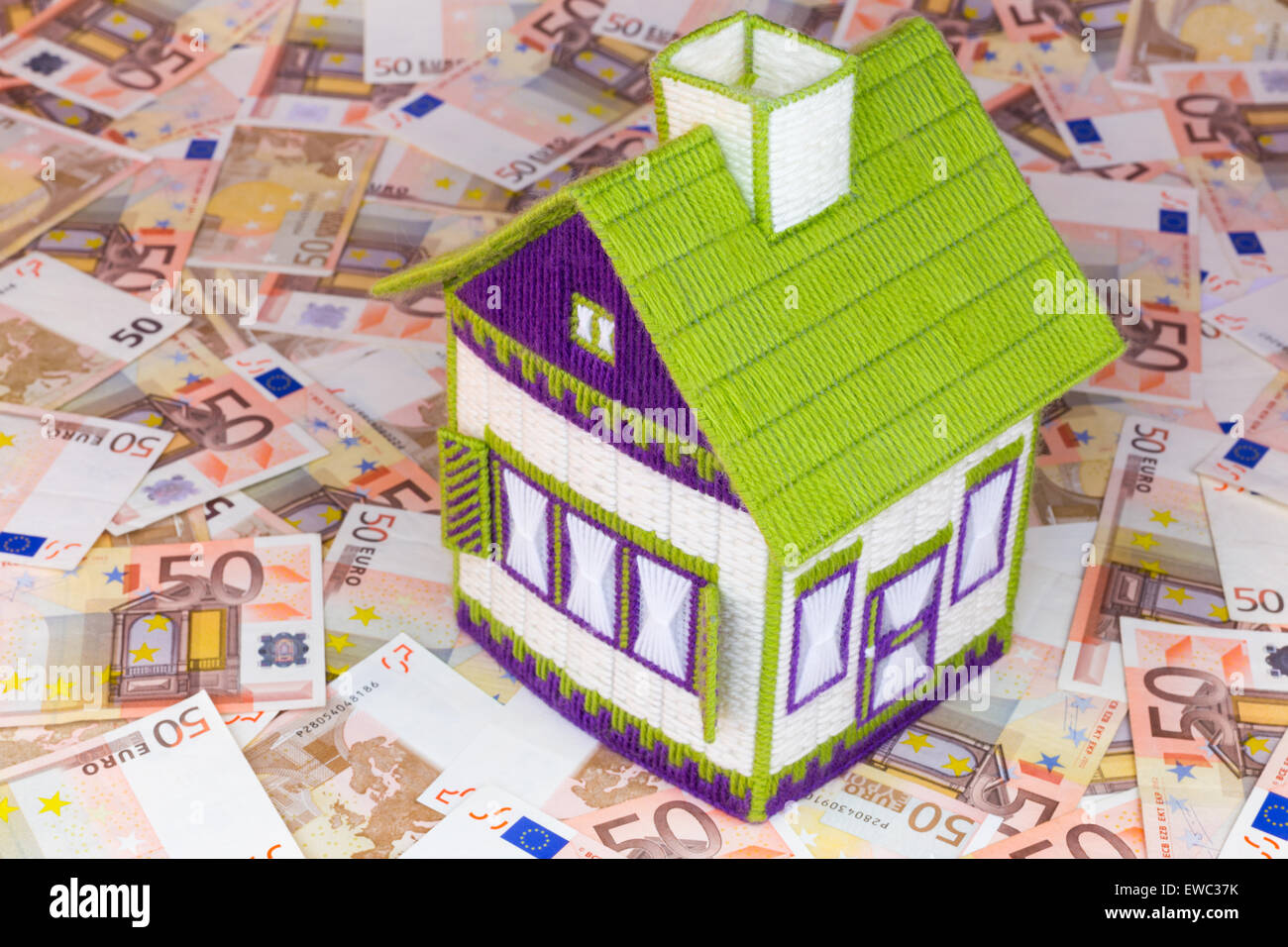 Bestickte Modell Häuschen am Tisch gefüllt mit Euro-Geld Stockfoto