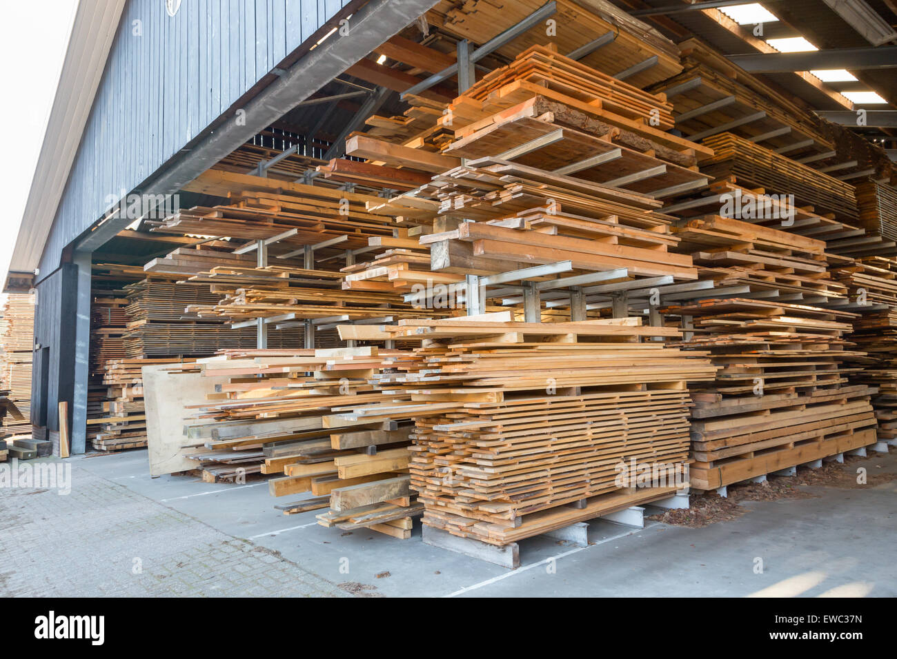 Stapel von Holzbohlen in Scheune für die Lagerung und Verkauf Stockfoto