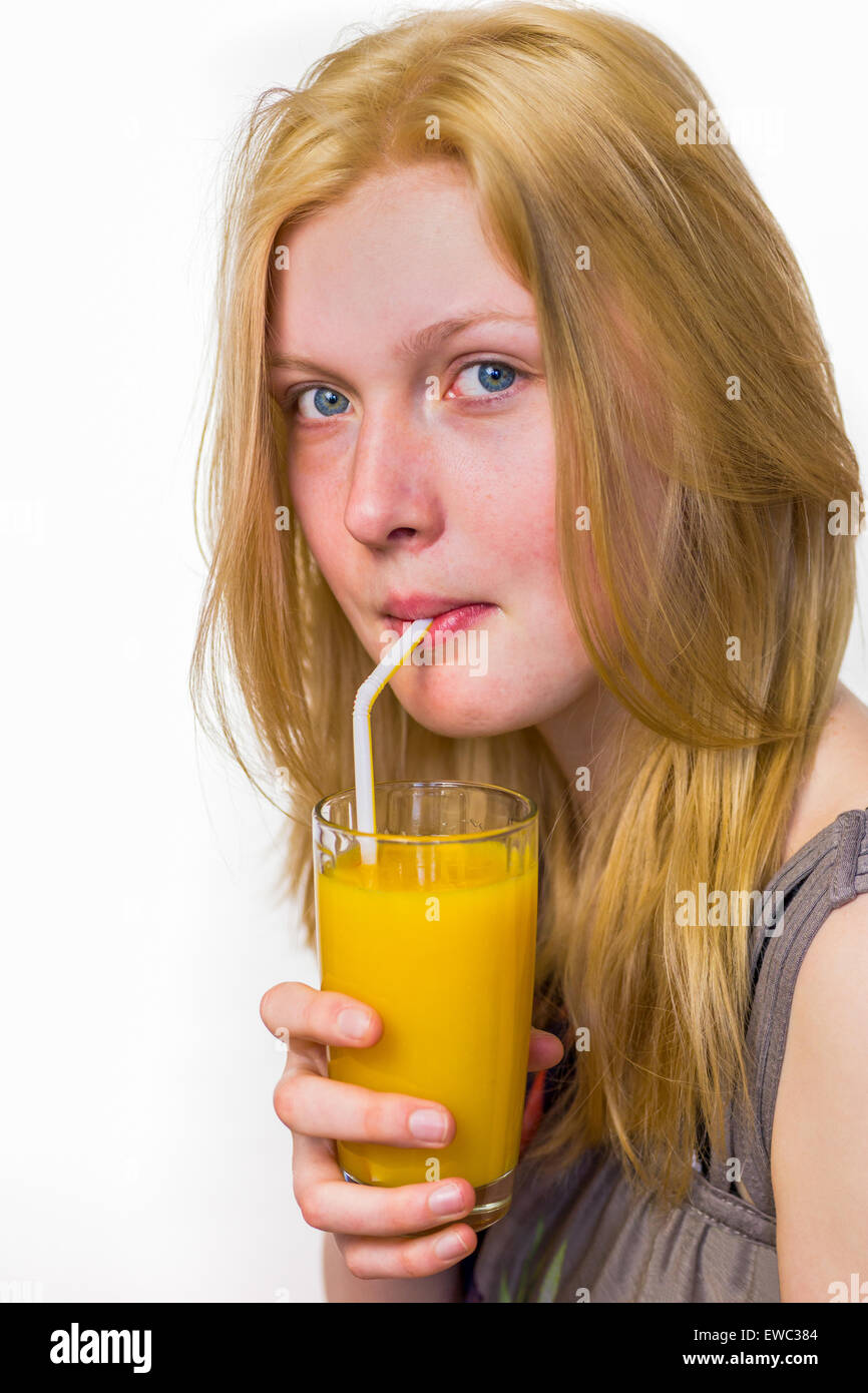 Blonde niederländische Teenager trinken Orangensaft mit Stroh isoliert auf weißem Hintergrund Stockfoto