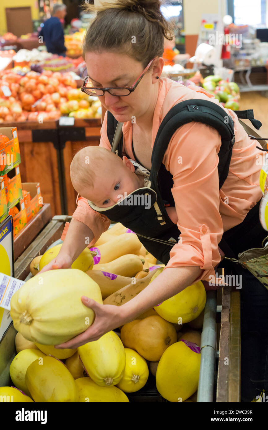 Wheat Ridge, Colorado - eine junge Frau, die Geschäfte in einem Supermarkt mit ihrem 11 Monate alten Sohn. Stockfoto