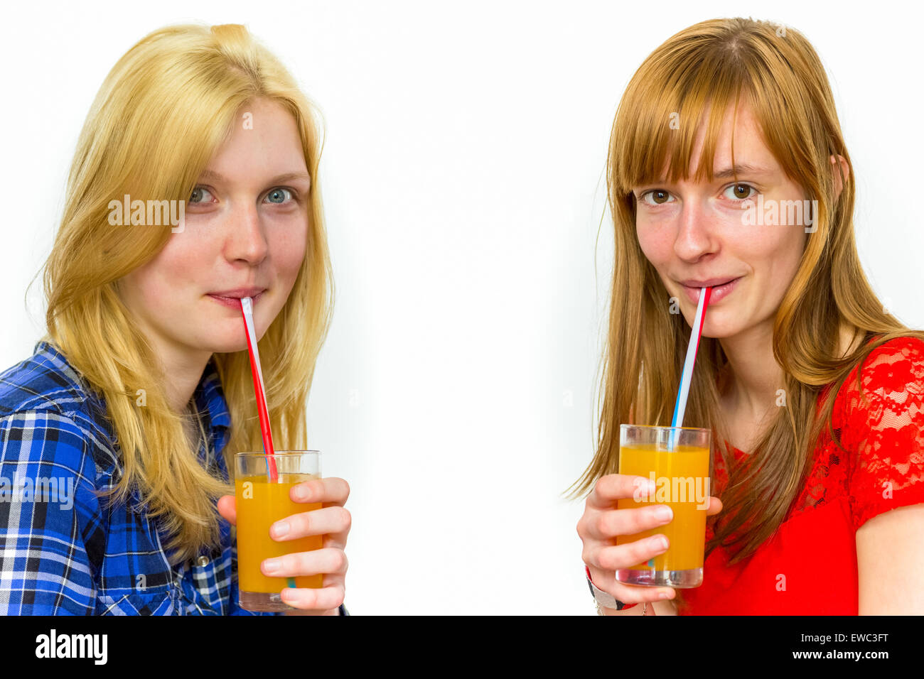 Zwei kaukasischen Teenager Freundinnen trinken Orangensaft isoliert auf weißem Hintergrund Stockfoto