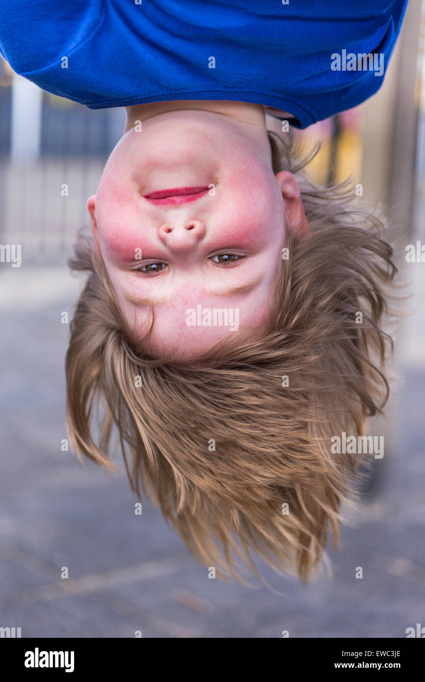 Junge Holländerin Kopf kopfüber am Spielplatz Stockfoto