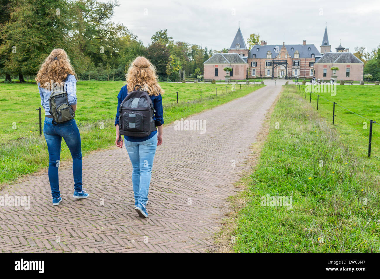 Zwei Mädchen im Teenageralter zu Fuß mit Rucksäcken auf den Weg zum Schloss Stockfoto