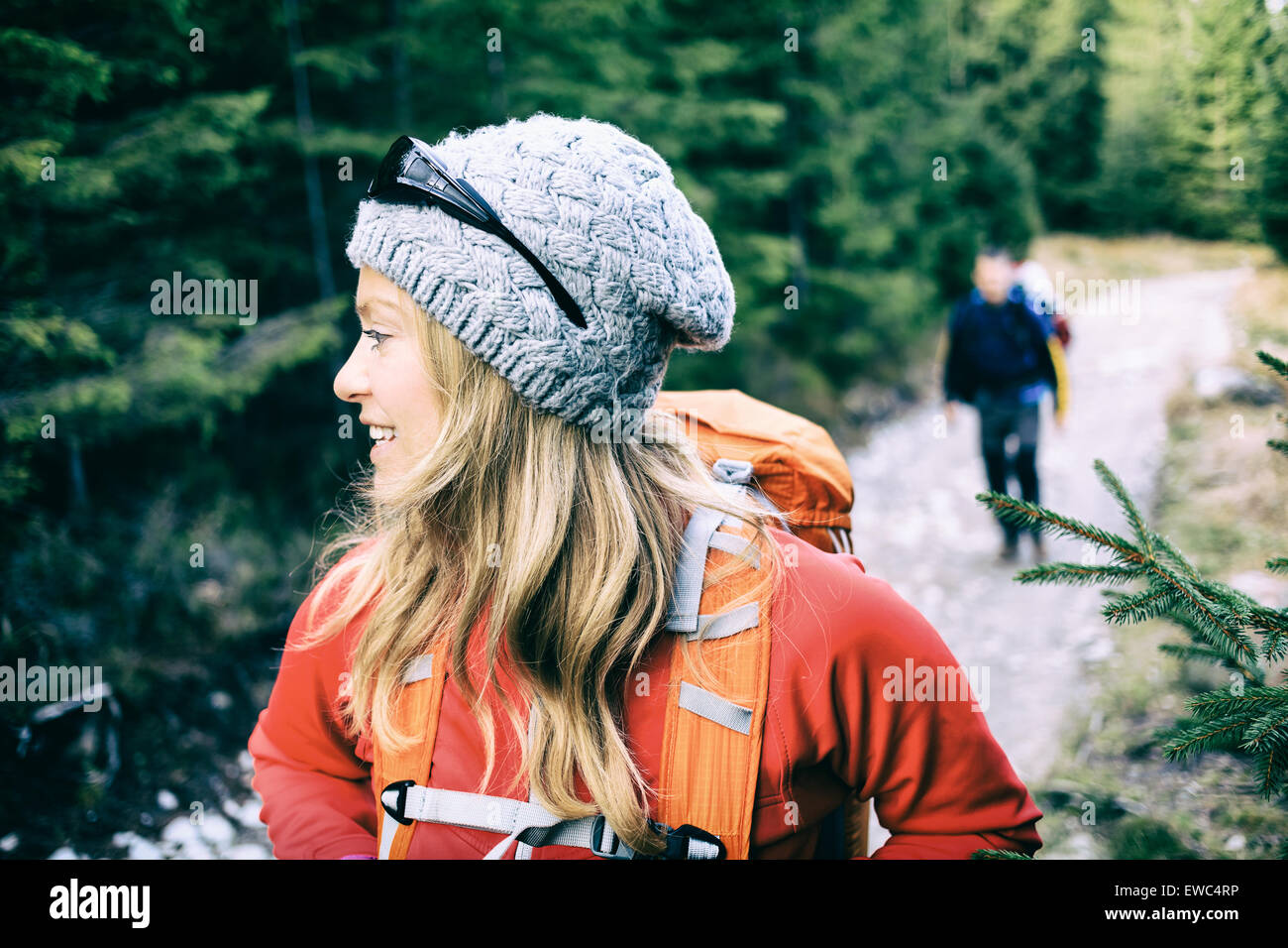 Mann und Frau Wanderer zu Fuß mit Rucksäcken unterwegs im grünen Wald Berge. Junges Paar, camping und trekking auf Land roa Stockfoto