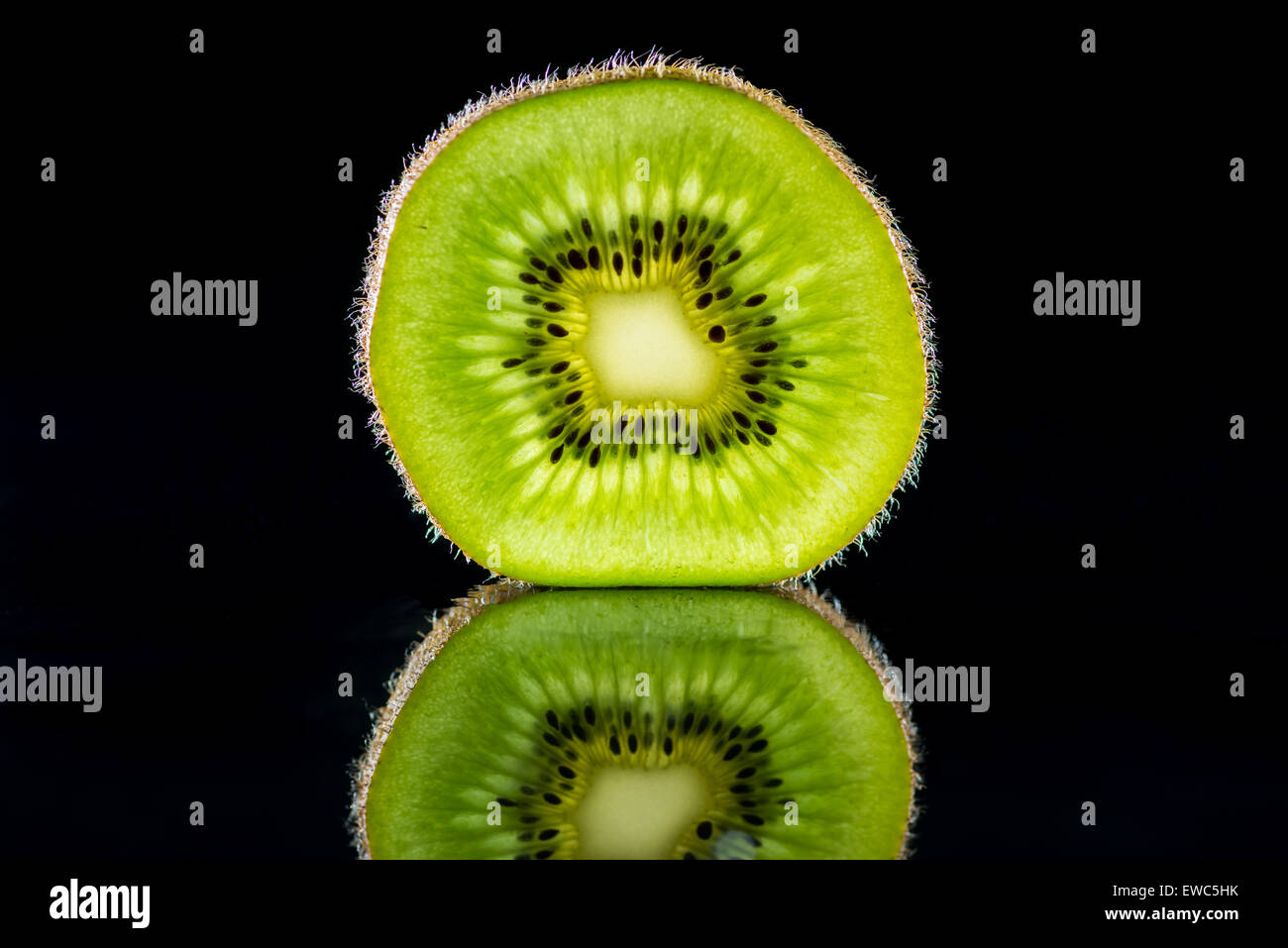 Kiwis in Scheiben schneiden mit Reflexion auf schwarzem Hintergrund Stockfoto