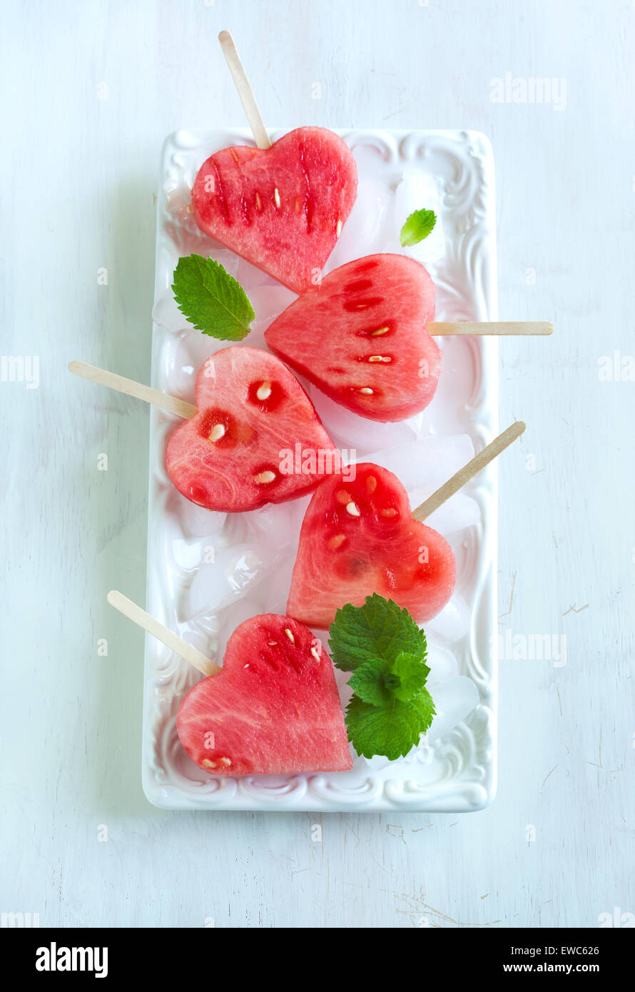 Wassermelone-Pops. Wassermelone-Scheiben in Herz-Form-Stücke schneiden. Stockfoto