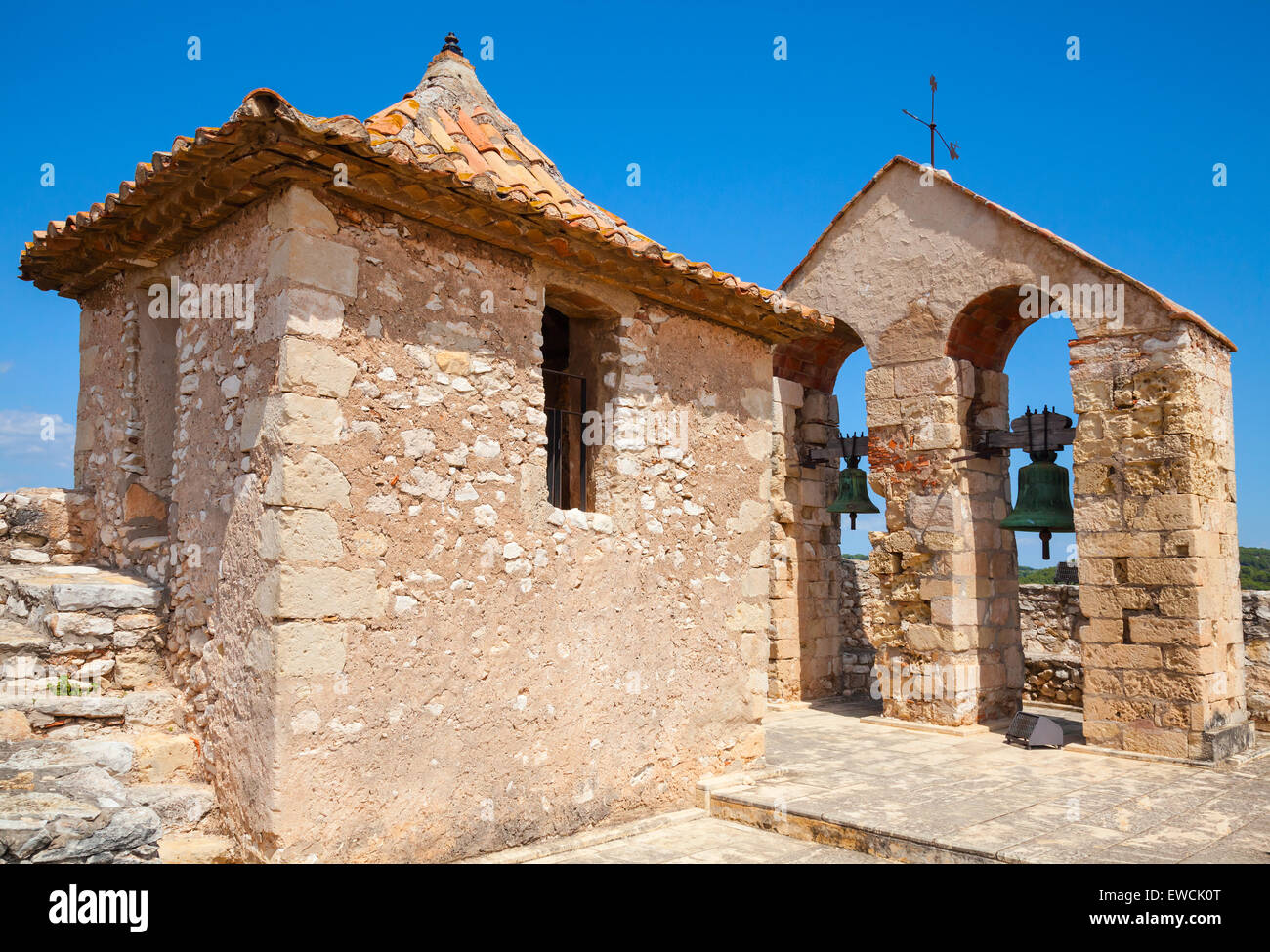 Mittelalterliche steinerne Burg in der Stadt von Calafell, Spanien. Turm und Glocken in Bögen Stockfoto