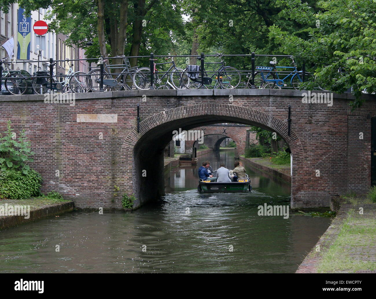 Personen auf einem Schiff unter einer Brücke am Nieuwegracht Kanal in der mittelalterlichen Innenstadt von Utrecht, Niederlande Stockfoto