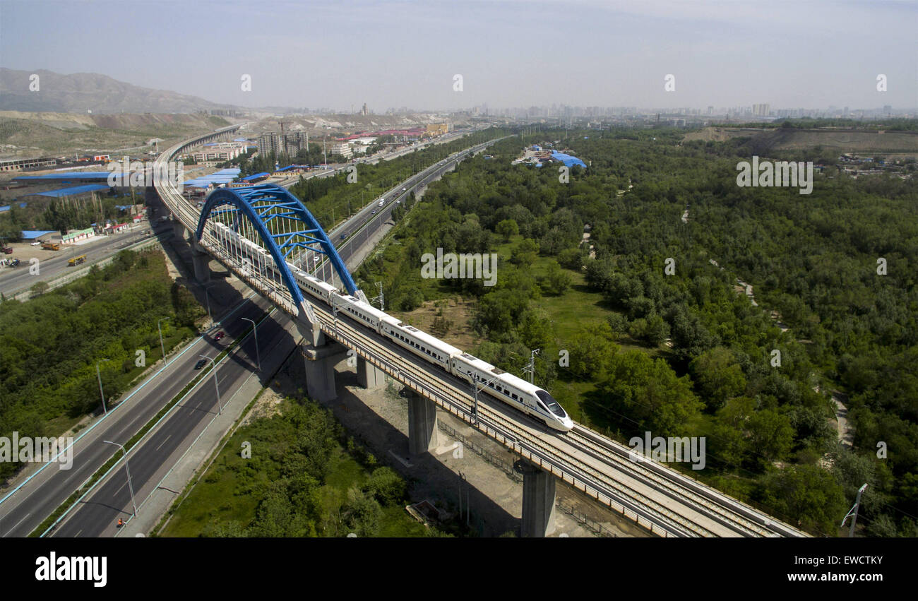 (150623)--URUMQI, 23. Juni 2015 (Xinhua)--am 27. Mai 2015 mit einer Drohne aufgenommenes Foto zeigt ein Hochgeschwindigkeitszug durchläuft die Stadt Urumqi, Hauptstadt von Nordwesten Chinas Xinjiang Uygur Autonome Region. Die 1.776 Kilometer Lanxin Schnellfahrstrecke wurde in Betrieb am 26. Dezember 2014, verbindet Lanzhou, die Hauptstadt der Provinz Gansu, Xining, Hauptstadt der Provinz Qinghai und Urumqi, alle im Nordwesten Chinas genommen. Im Jahr 2015 Xinjiang Teil der Lanxin Schnellfahrstrecke wurden Luftaufnahmen von einer Gruppe von Luftaufnahmen von Xinhua News Agency und verschiedenen Landschaftsformen von Xinjiang aufgezeichnet wurden Stockfoto