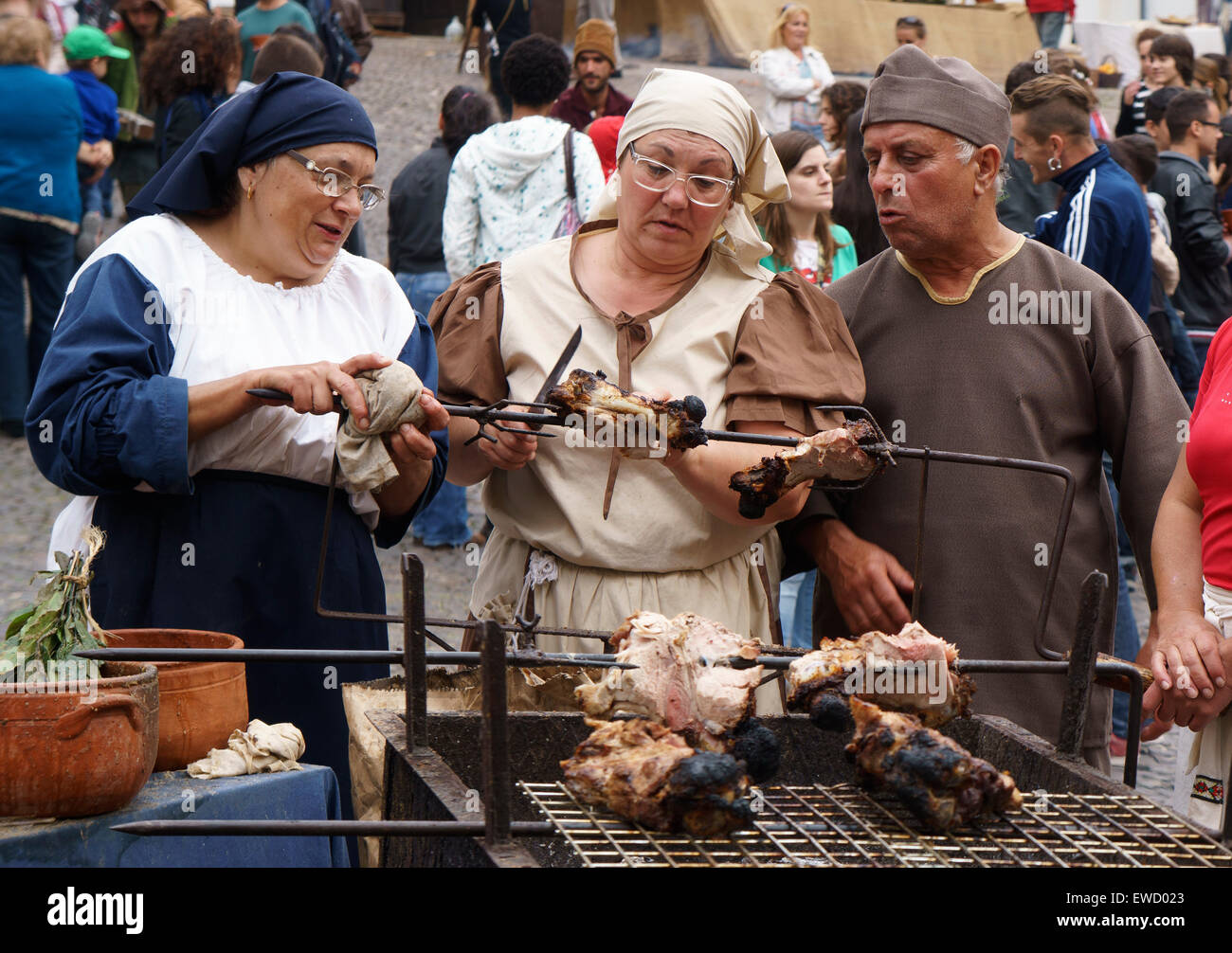 Menschen gekleidet in mittelalterliche Kleidung Braten Fleisch während  einer Renaissance Messe in Coimbra, Portugal, Europa Stockfotografie - Alamy