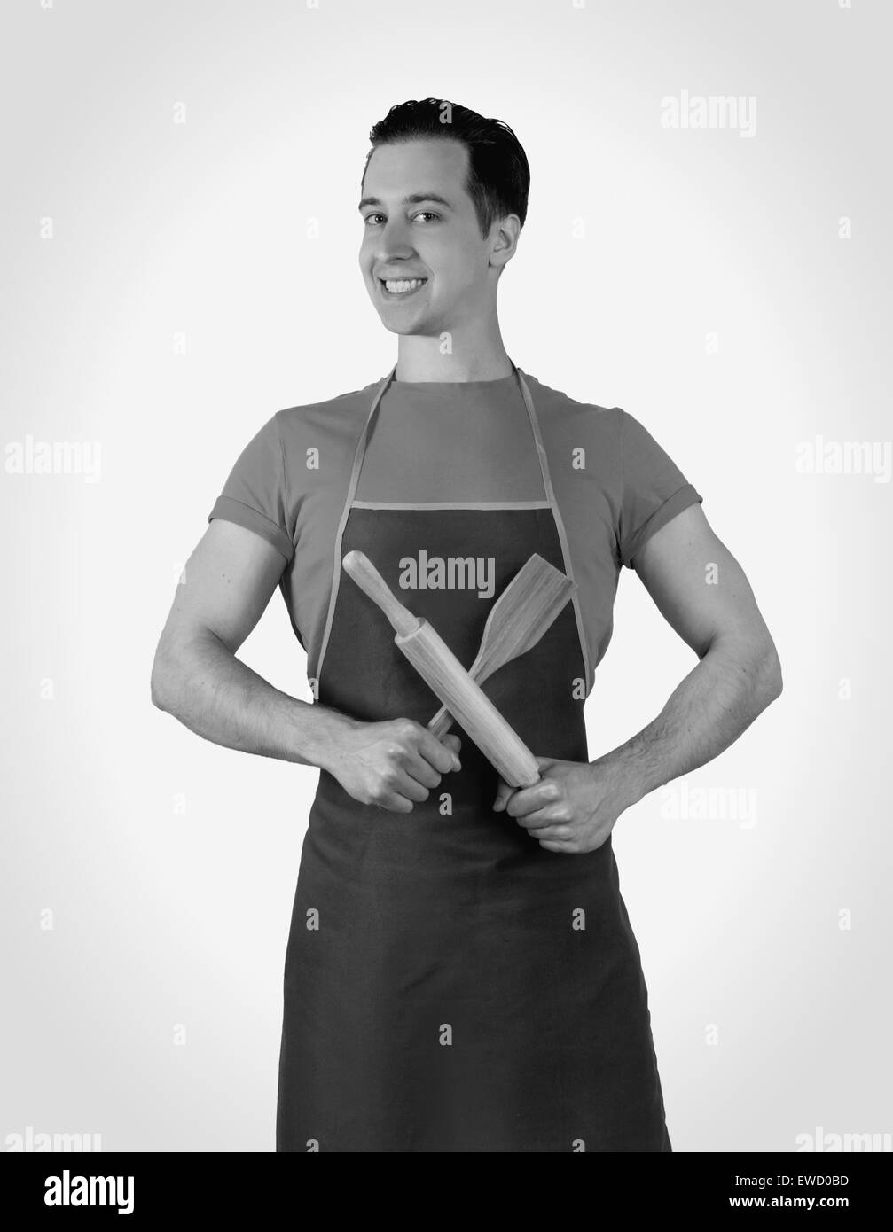 Der Mann in der Küche trägt eine Schürze mit einem Nudelholz. isoliert Stockfoto