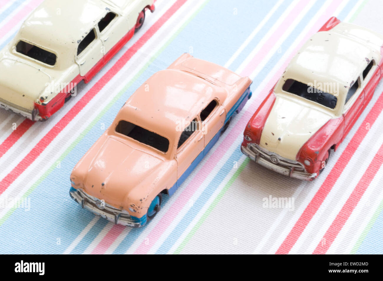 Dieselben drei schäbigen Autos, in verschiedenen Farben, fahren auf einer imaginären Autobahn Stockfoto