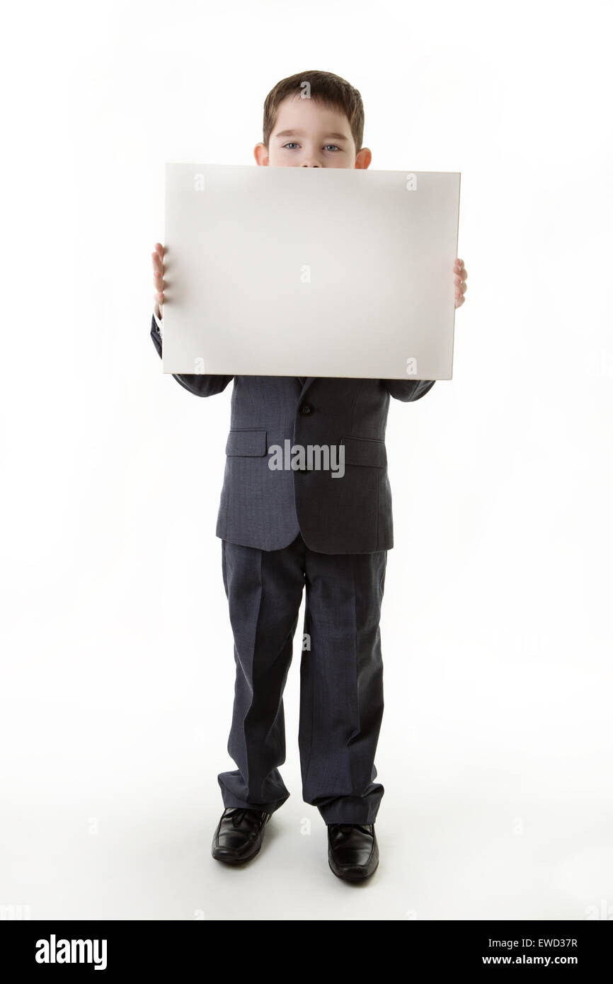 kleiner Junge hält eine leere Karte verkleidet in einem Business-Anzug Stockfoto