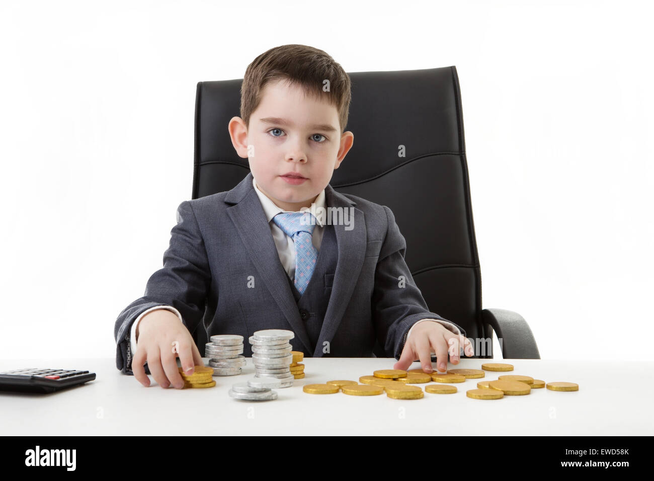 kleine Jungen so zu tun, er arbeitet in einem Büro Schokolade Geldzählen Stockfoto