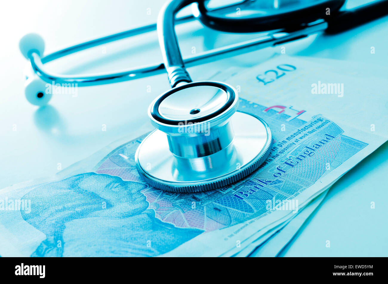 ein Stethoskop auf einen Haufen von Rechnungen Pfund, zeigt das Konzept der health care Industrie im Vereinigten Königreich Stockfoto