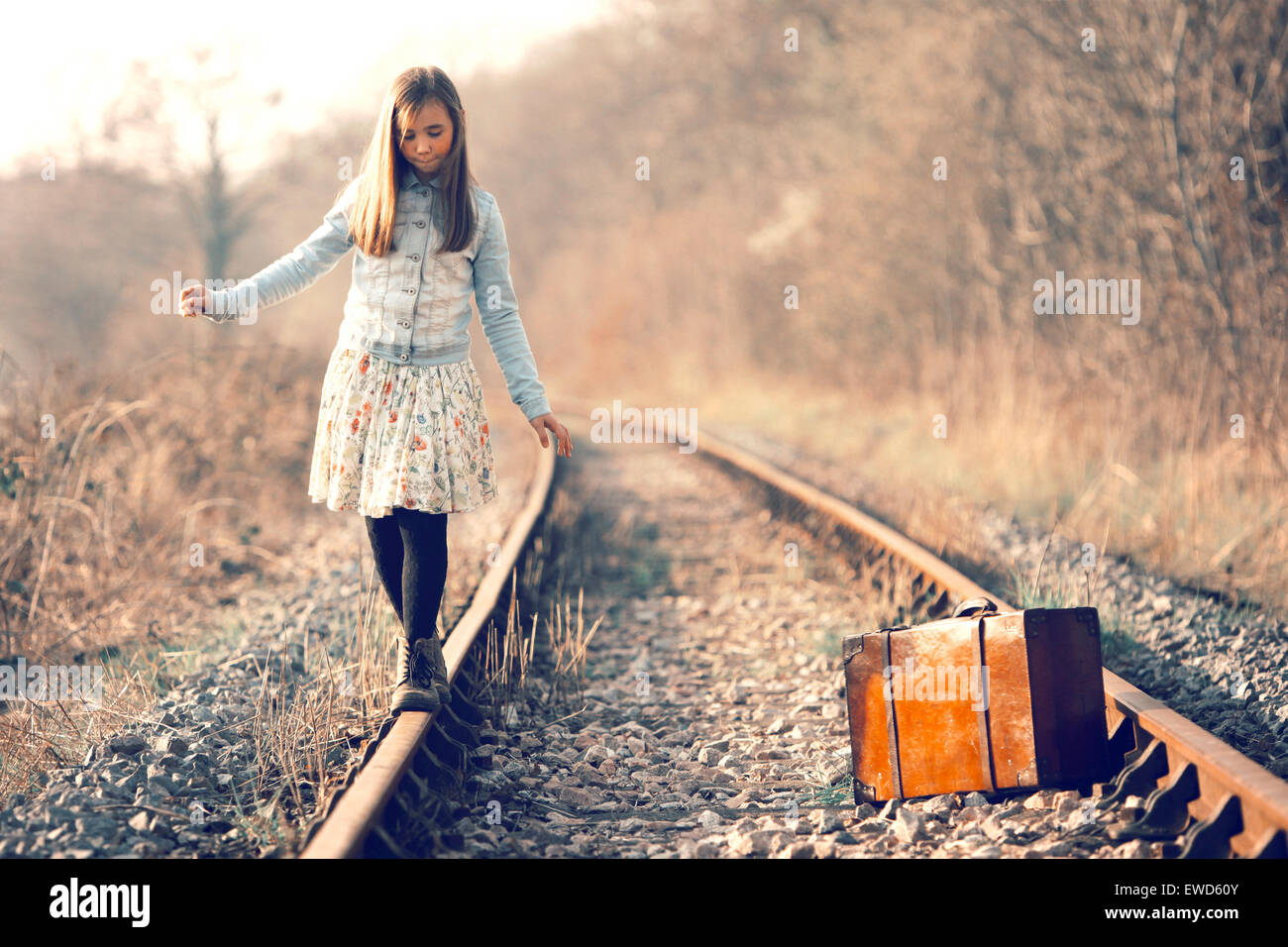 Außer Kontrolle geratenen Mädchen hat Spaß auf einer ungenutzten Landes Eisenbahn Spur Stockfoto