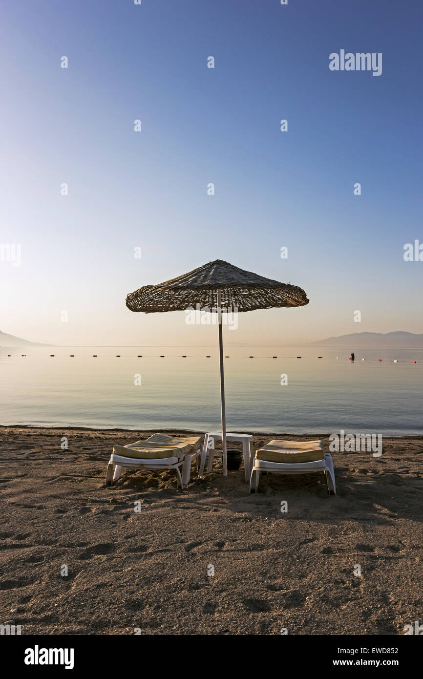 Schatten und Sonne Liegestühle am Strand Akyarlar in Turgutreis-Region der Türkei in den frühen Morgenstunden Stockfoto
