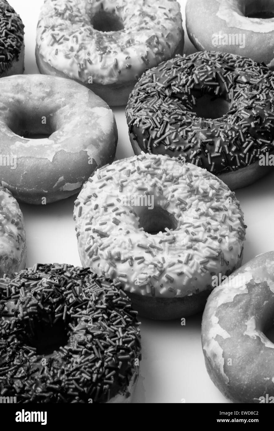 große Auswahl an Donuts, viele verschiedene Geschmacksrichtungen, geschossen auf weißem Hintergrund Stockfoto