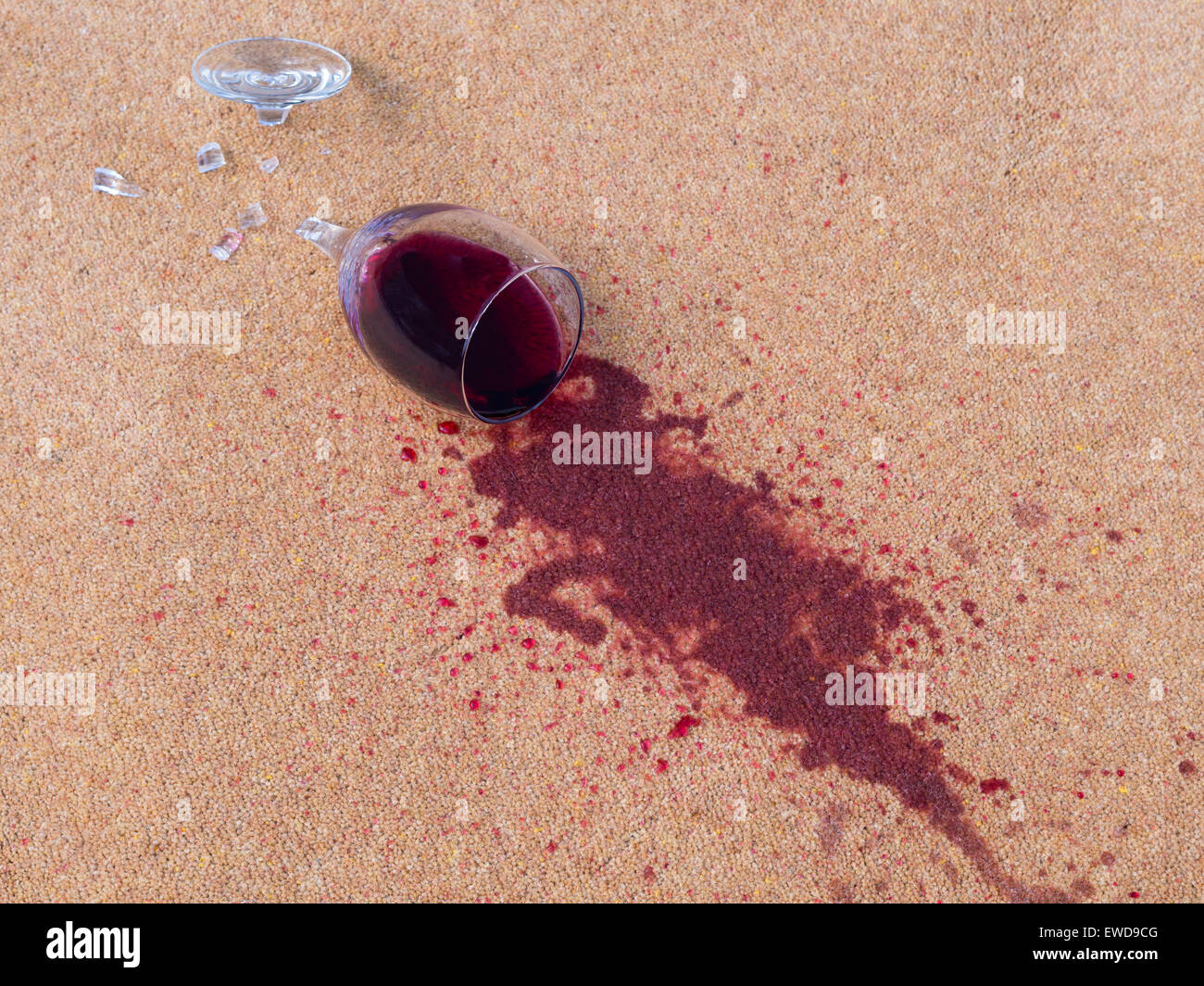 Glas Rotwein auf dem Teppich gefallen Stockfoto