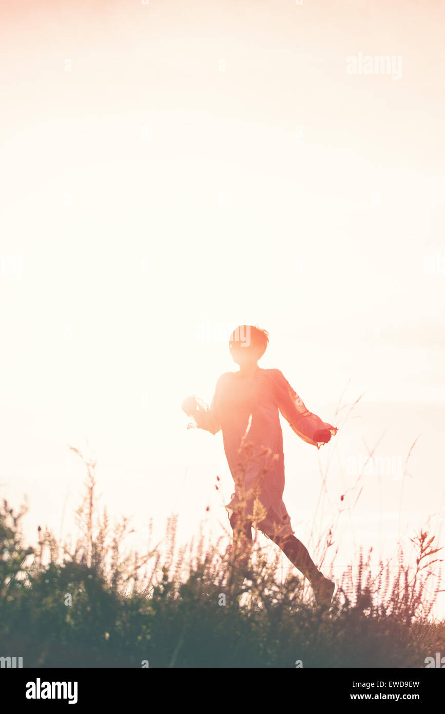 Frau läuft in die Freiheit durch Landschaft Feld, Silhouette der weiblichen Person, Doppelbelichtung, Vintage Retro-Ton-Effekt. Stockfoto