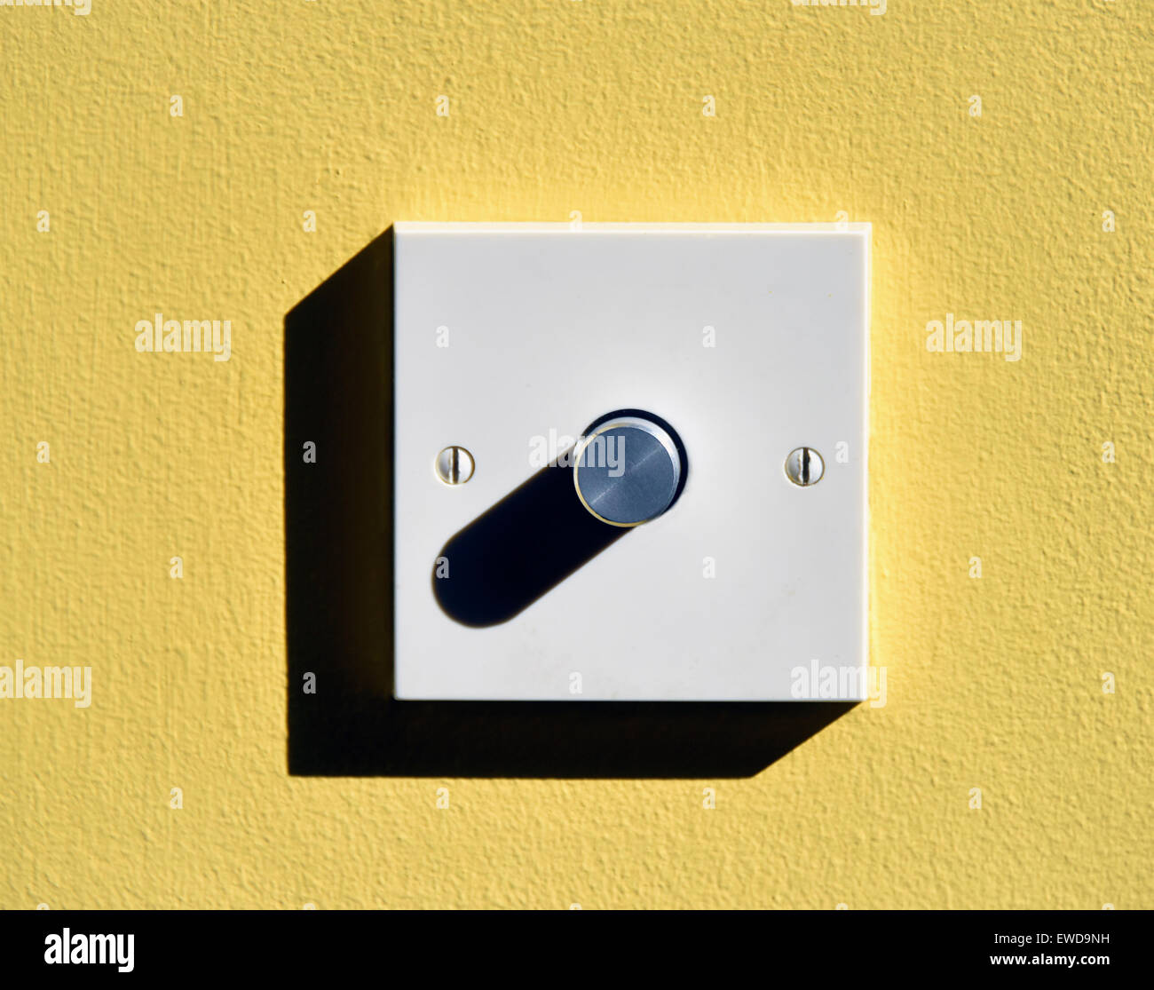 Elektrisches Licht-dimmer-Schalter auf gelbe Wand. Kendal, Cumbria, England, Vereinigtes Königreich, Europa. Stockfoto