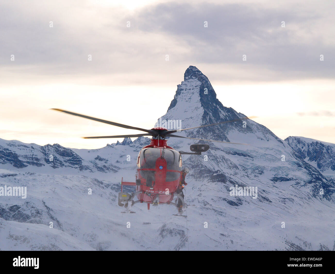 Ein Rettungshubschrauber vom Typ EC135 nähert sich die Szene von einem Unfall in den Bergen von Zermatt in den Schweizer Alpen. Die Stockfoto