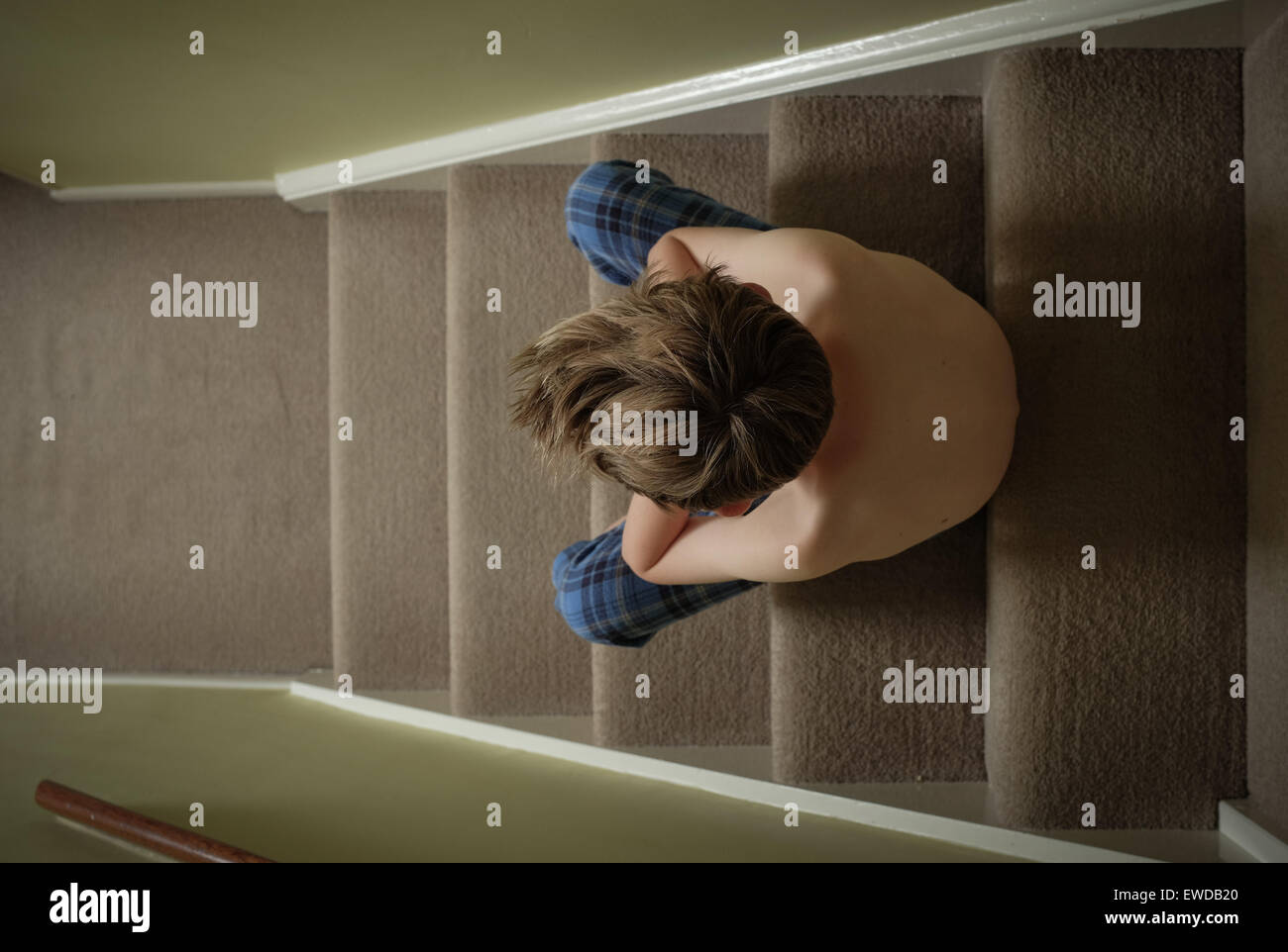 Ein Kind sitzt auf der Treppe mit dem Kopf in seine Hände suchen verärgert Stockfoto