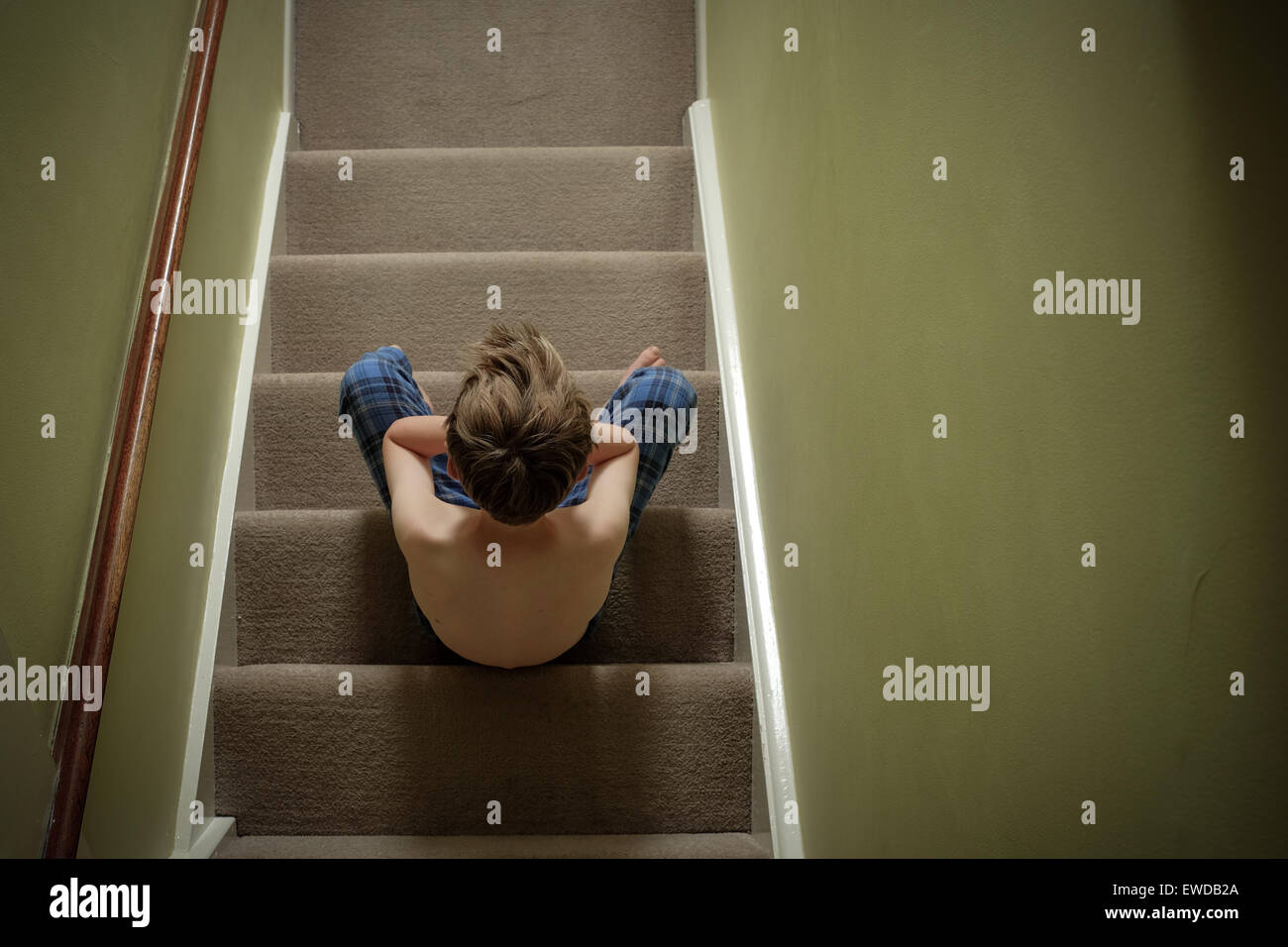 Ein Kind sitzt auf der Treppe mit dem Kopf in seine Hände suchen verärgert Stockfoto