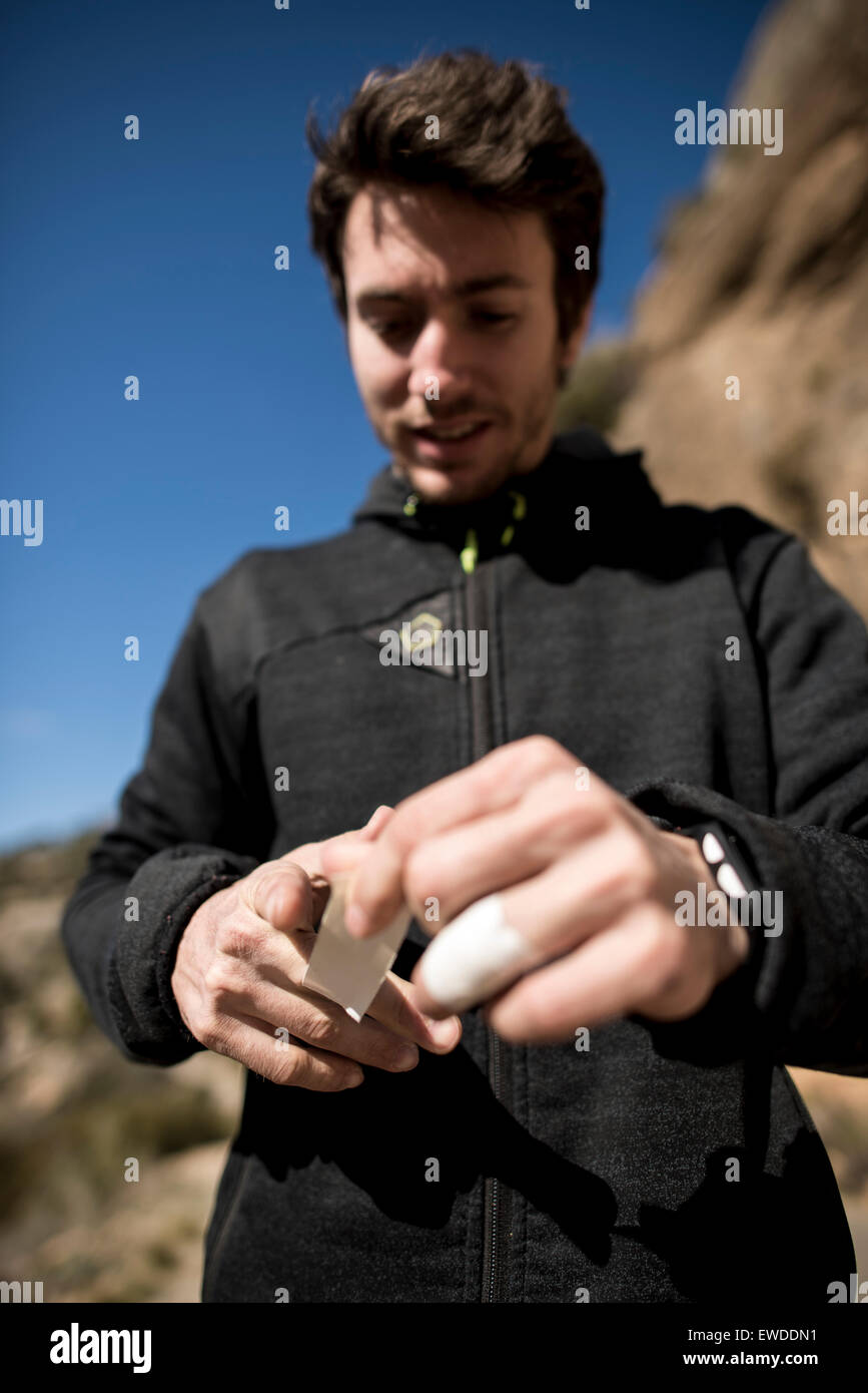 Italienischer Profi-Bergsteiger Stefano Ghisolfi taping seine Finger Befor machen die vierte Besteigung des Demencia Senil 9a + in Stockfoto