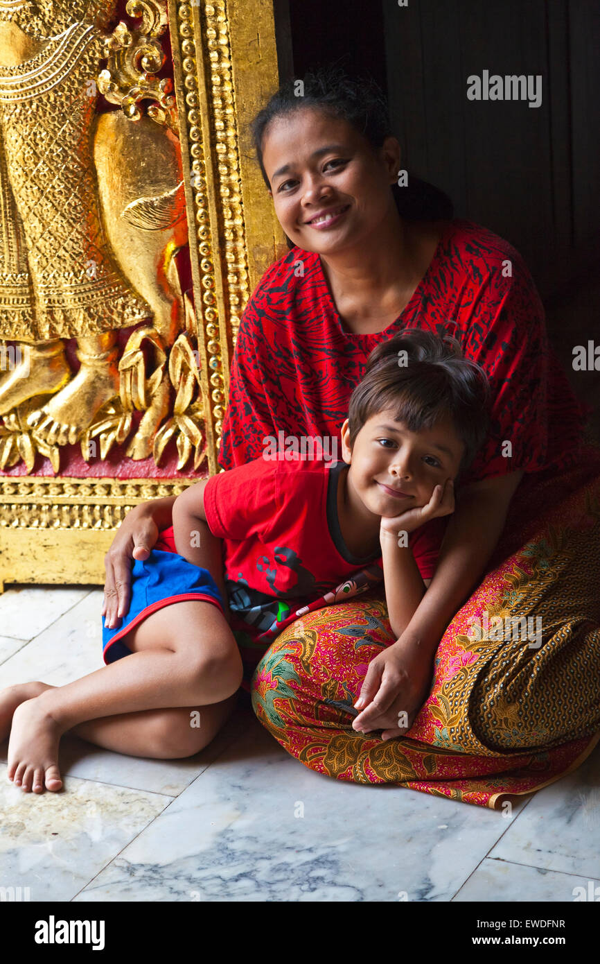 Thailändische Mutter und Kind in der buddhistischen WAT XIENG THONG (Tempel der goldenen Stadt), erbaut im Jahre 1560 - LUANG RACHENTUPFER, LAOS Stockfoto