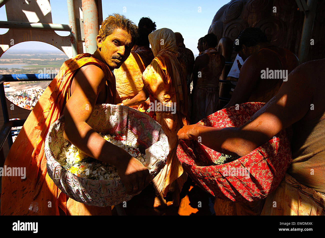 Indien Karnataka Sravanabelagola Pilger getränkt in Heilige Flüssigkeiten verwendet, um Salbe die Statue von Lord Bahubali tragen Körbe von Blütenblättern, die Statue zu verzieren Stockfoto