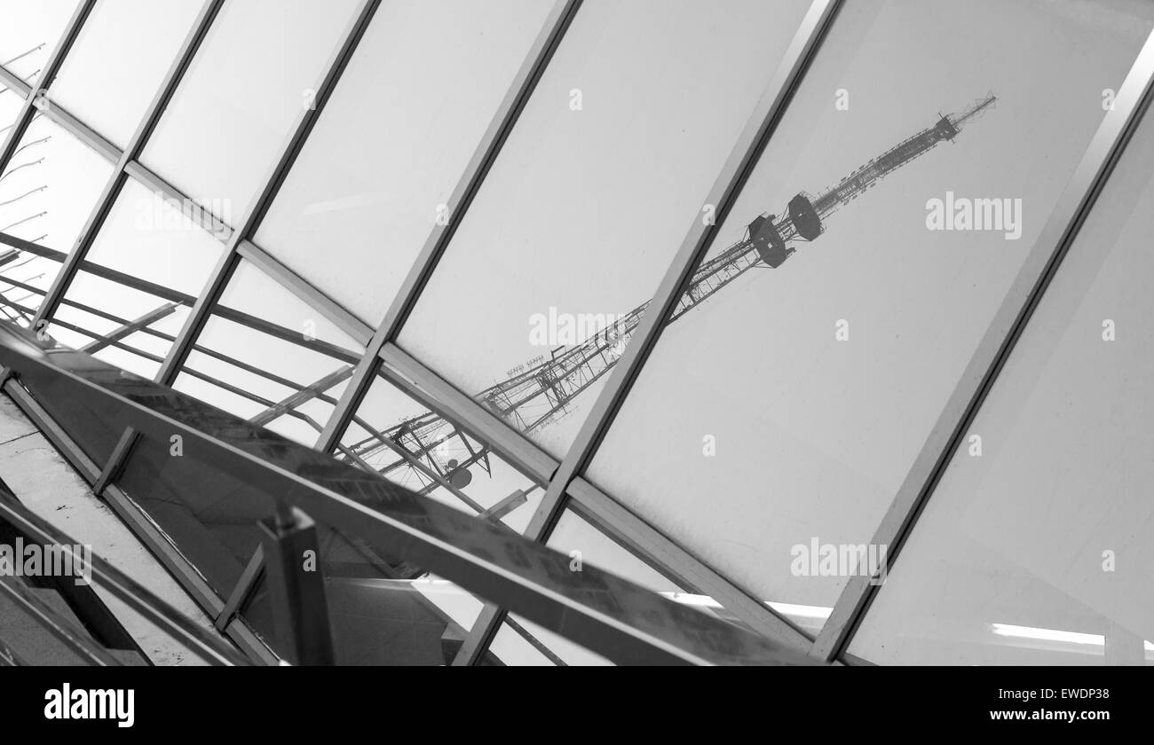 Riesiger Fernsehturm spiegelt sich in einem Glasfenster eines modernen Gebäudes in Monochrom Stockfoto